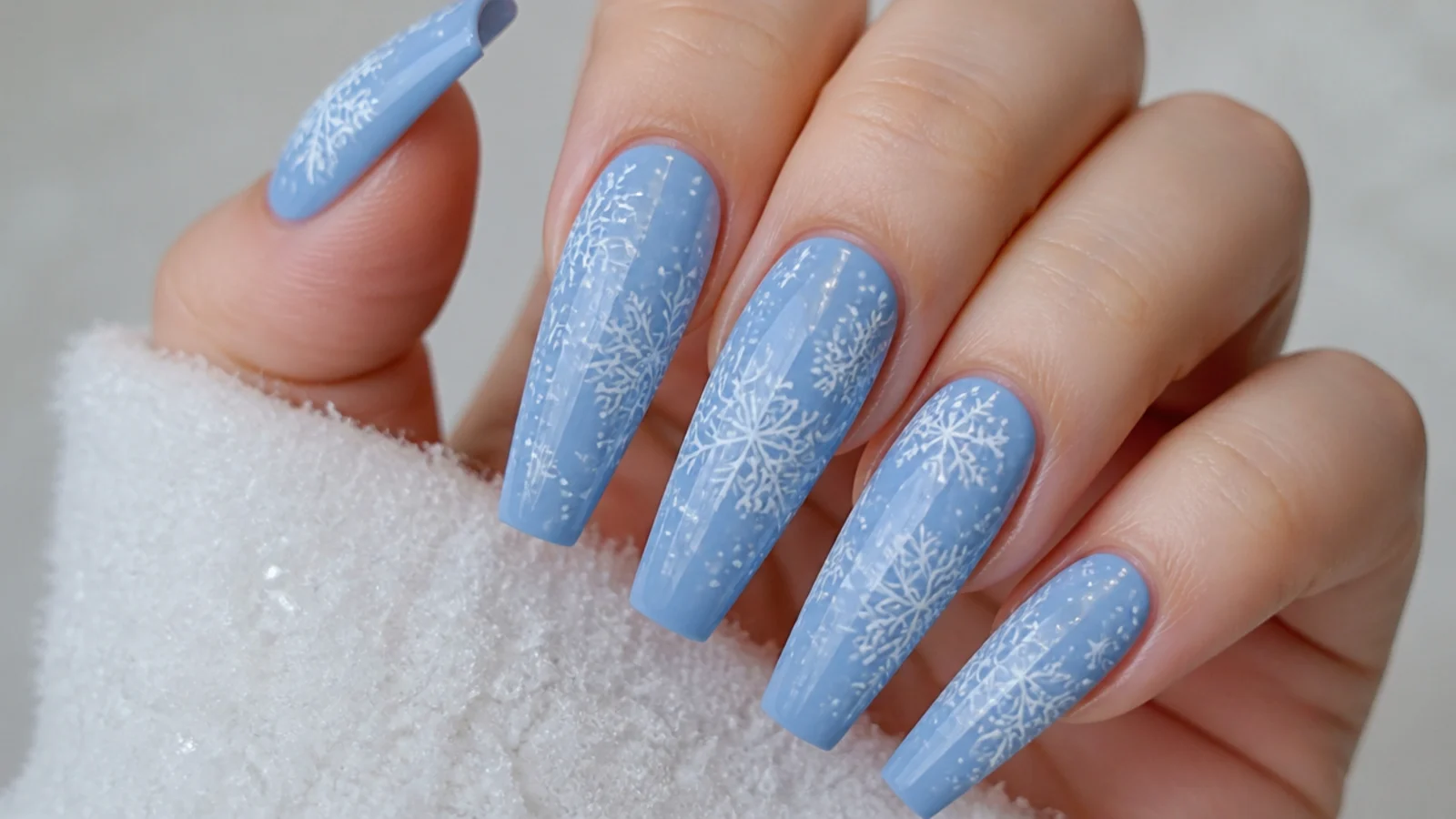 White snowflake on long coffin nails over an icy blue base