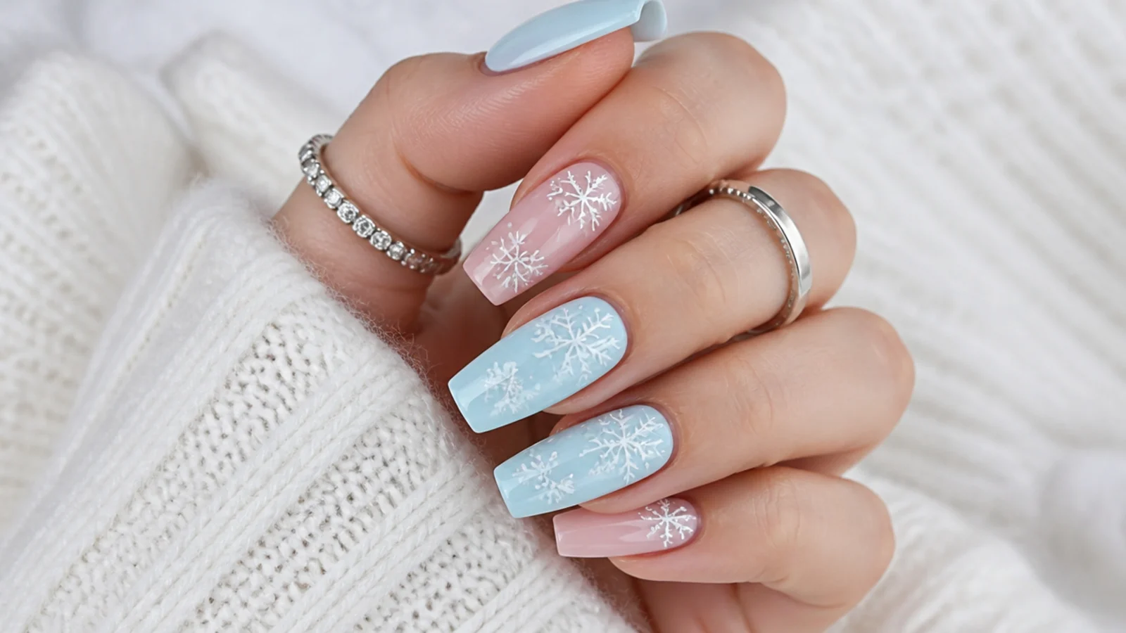 Pastel blue and pink acrylic nails with white snowflakes