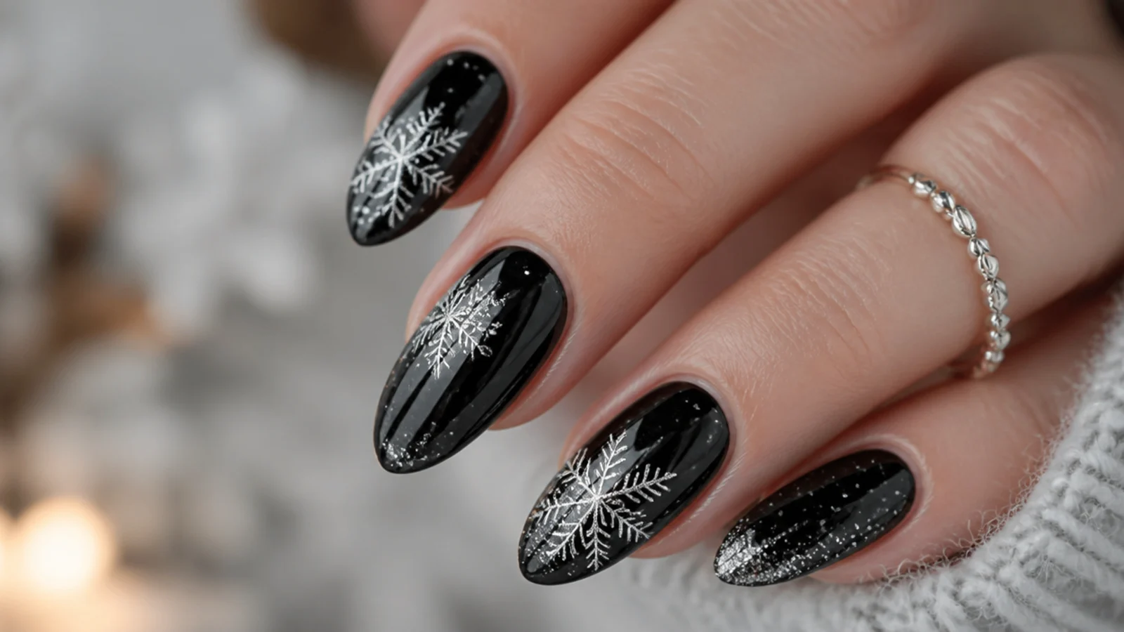 Glossy black snowflake nails with fine silver flakes and glitter