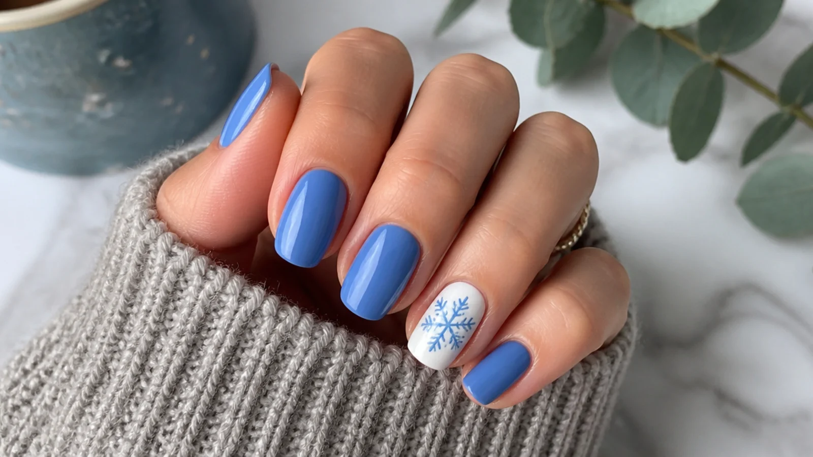 Short blue nails with one white snowflake accent nail