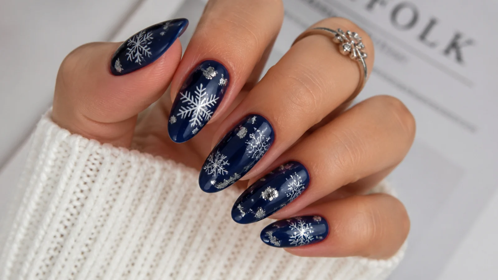Navy snowflake nails with silver foil flakes and painted white flakes
