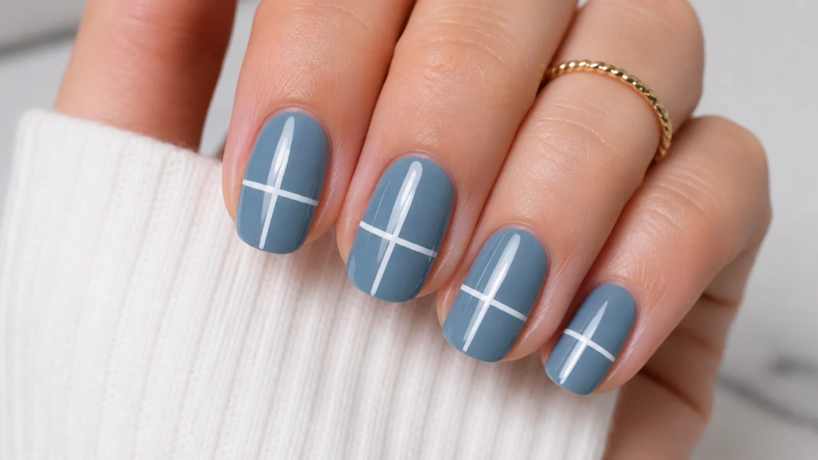A thin white vertical and horizontal line forming a plus sign on a blue nail