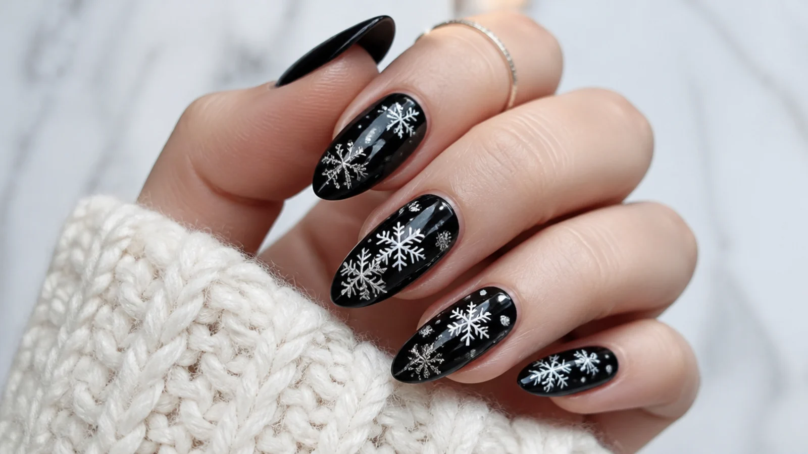 Black winter snowflake nails with white and silver snowflakes for a high-contrast set