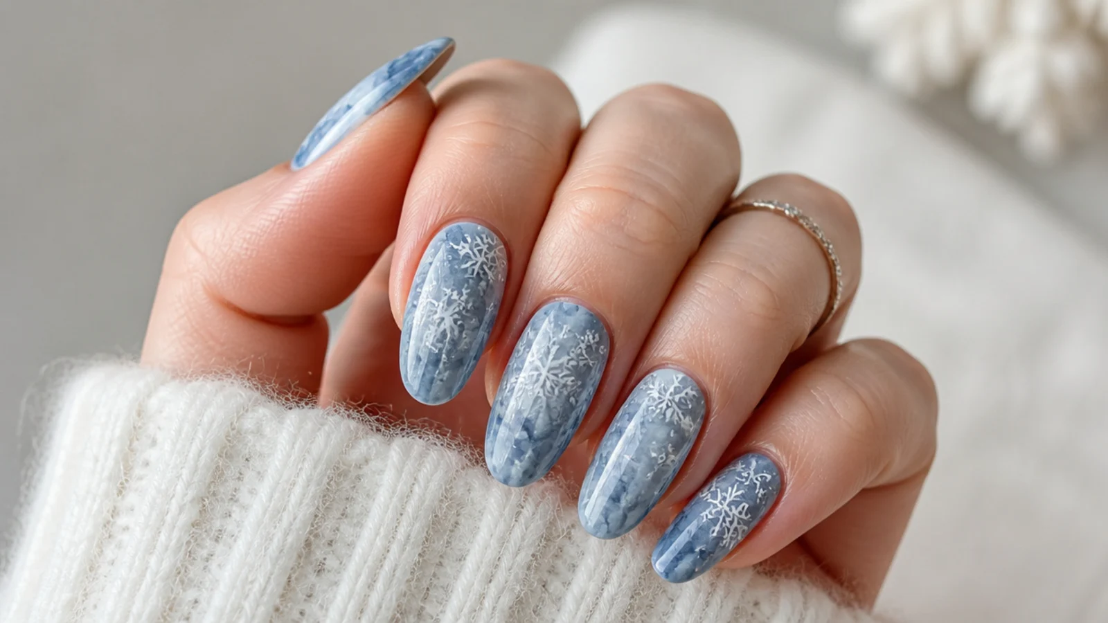 Dusty blue marble winter snowflake nails with white snowflakes over veined base