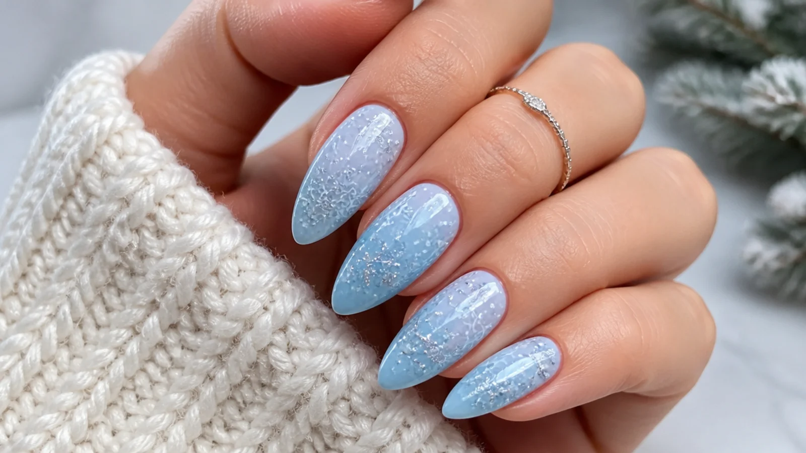 Icy blue winter snowflake nails with fine white and silver snowflakes on an almond shape