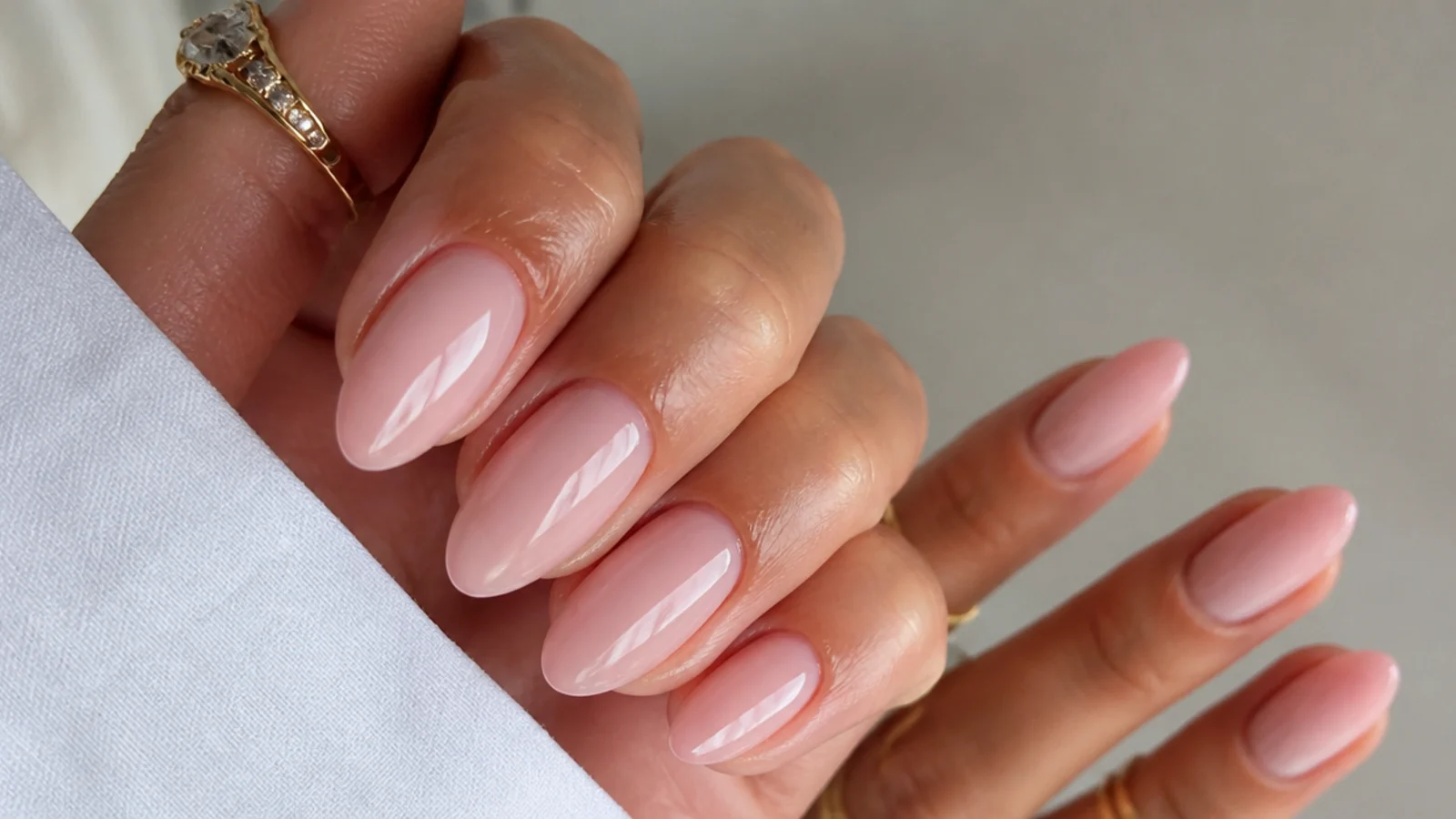 Sheer soft pink-nude almond soap nails in an OPI Bubble Bath style shade