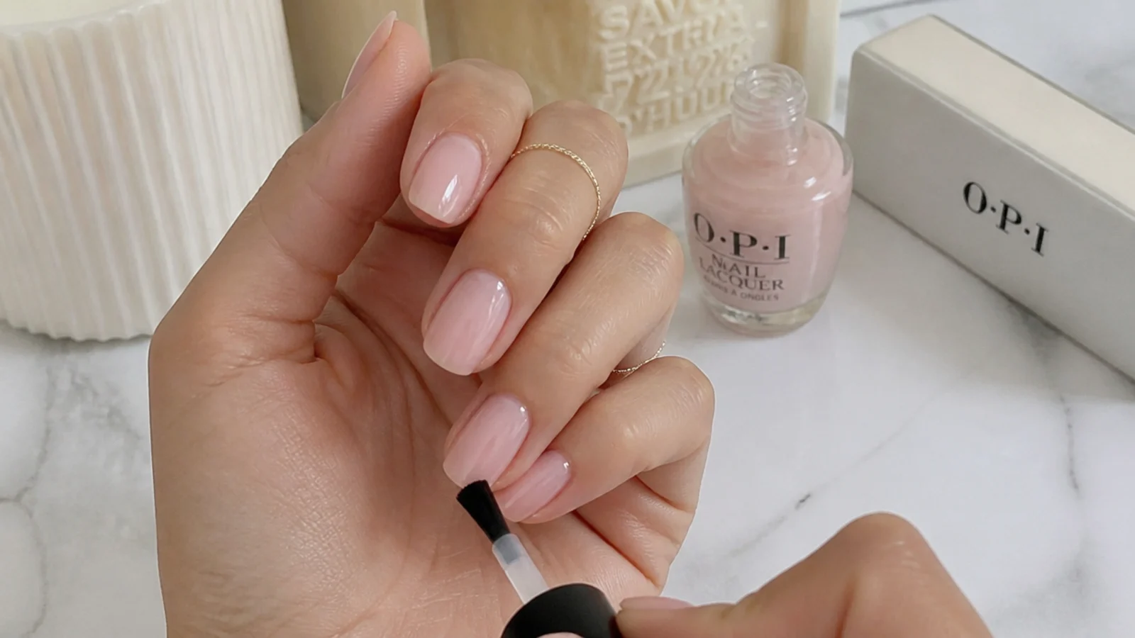 Home soap-nail supplies with a buffer, sheer OPI polish and a nail mid-application