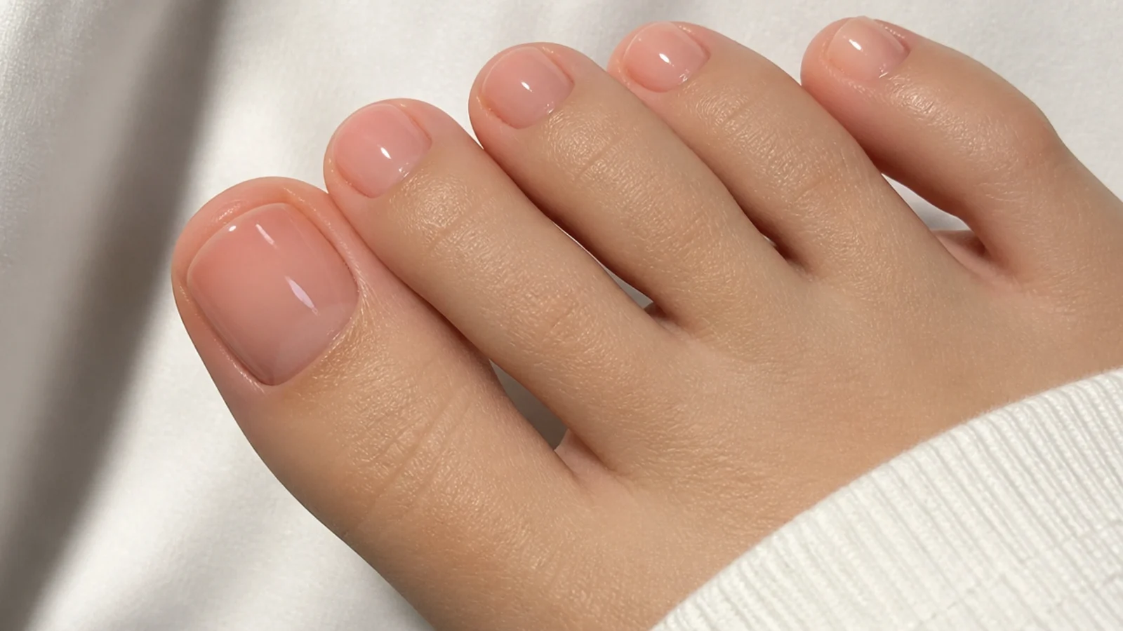 Nearly bare buffed soap pedicure with a clear glossy glass-like finish on toes