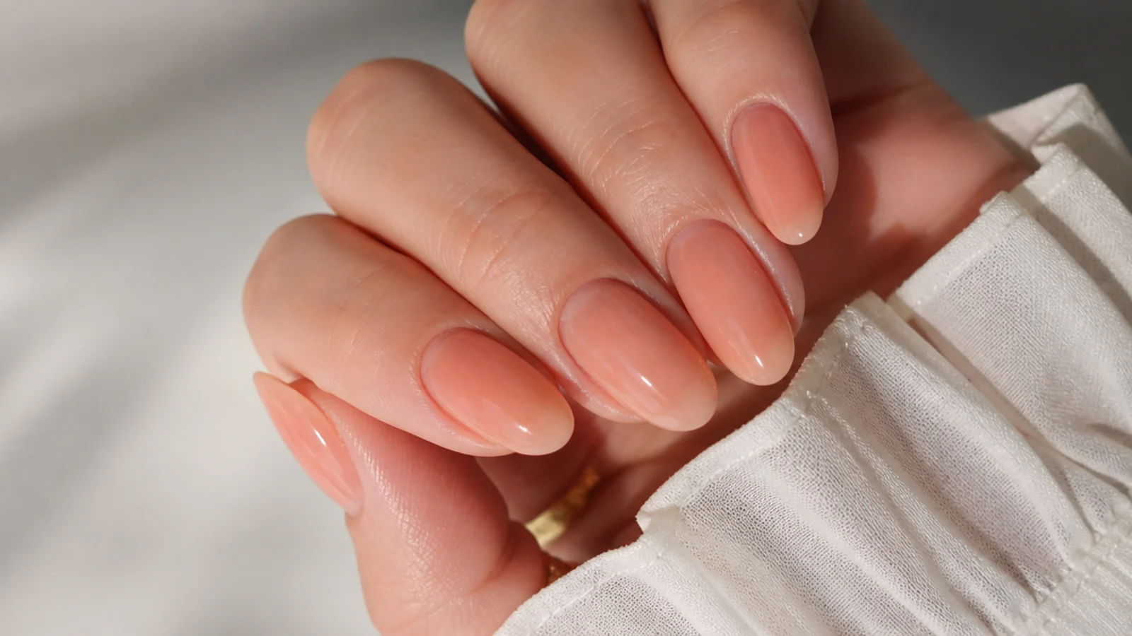 Sheer warm peach soap nails on oval shape with a soft glow