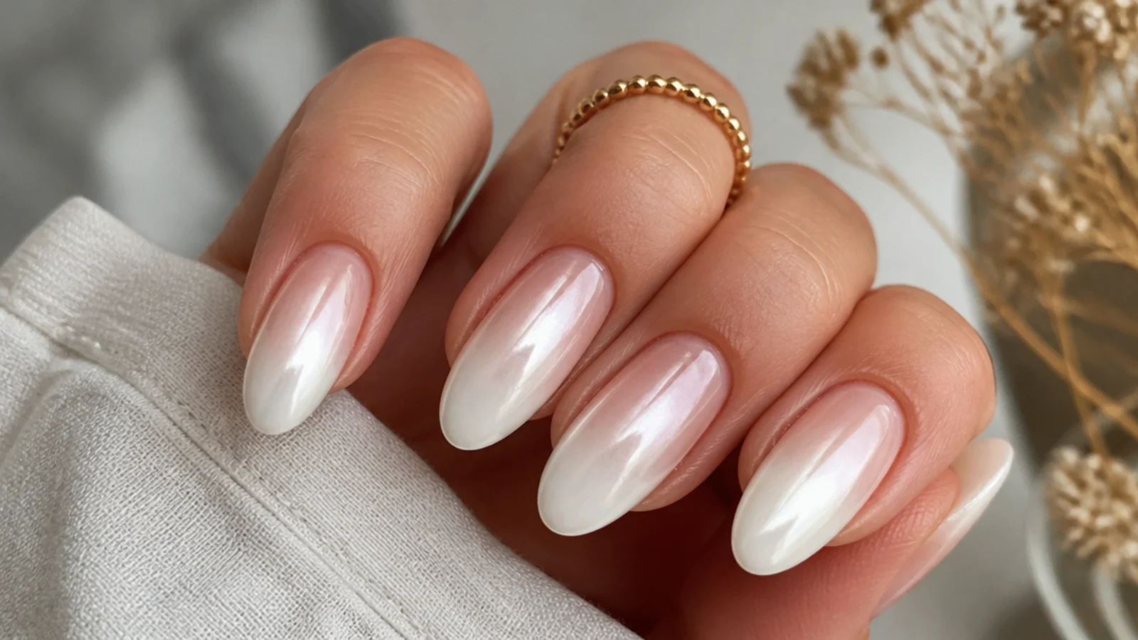 White chrome nails fading from nude at the cuticle to pearl at the tip