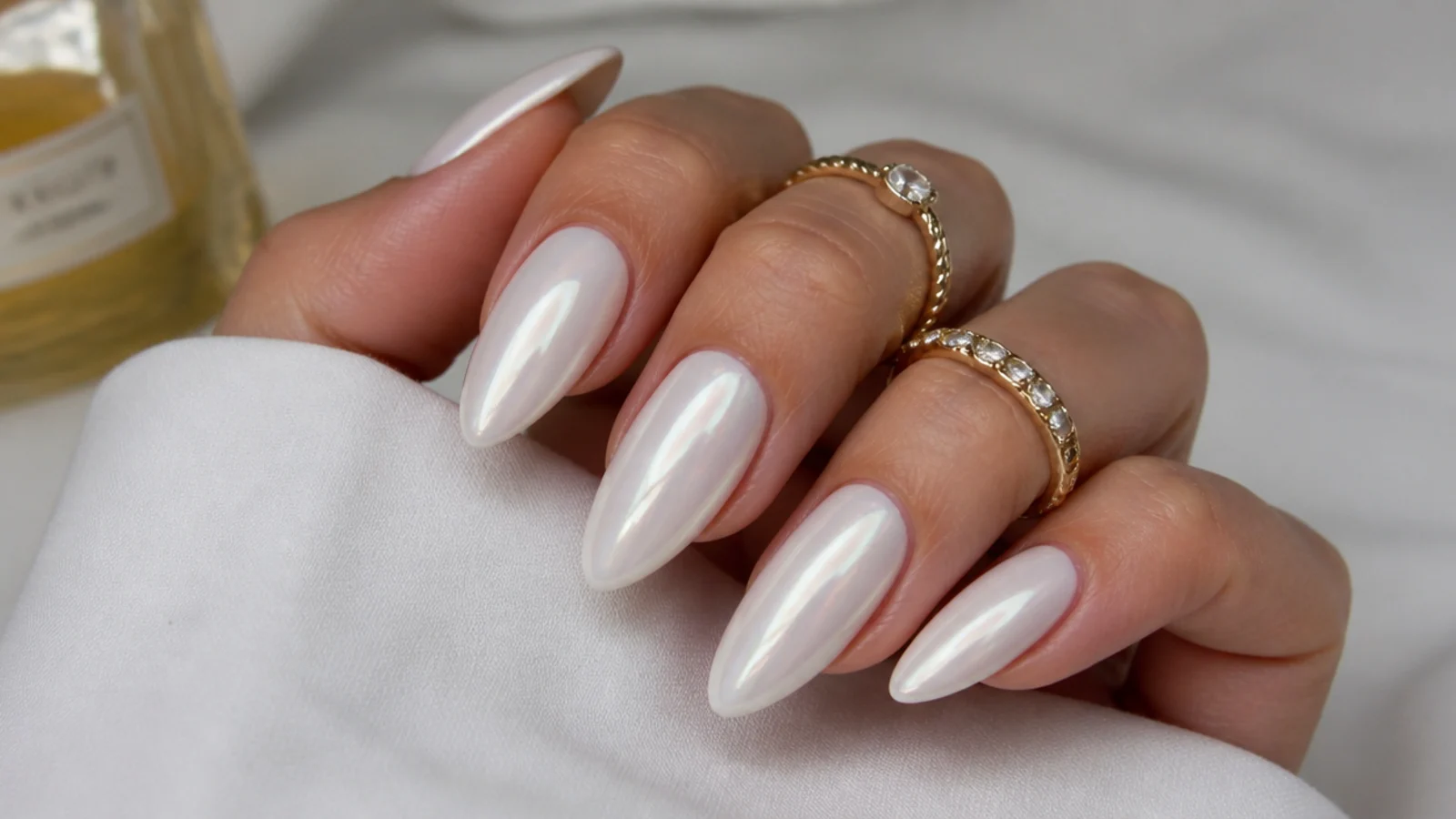 Long milky white chrome almond nails with a soft pearl glow