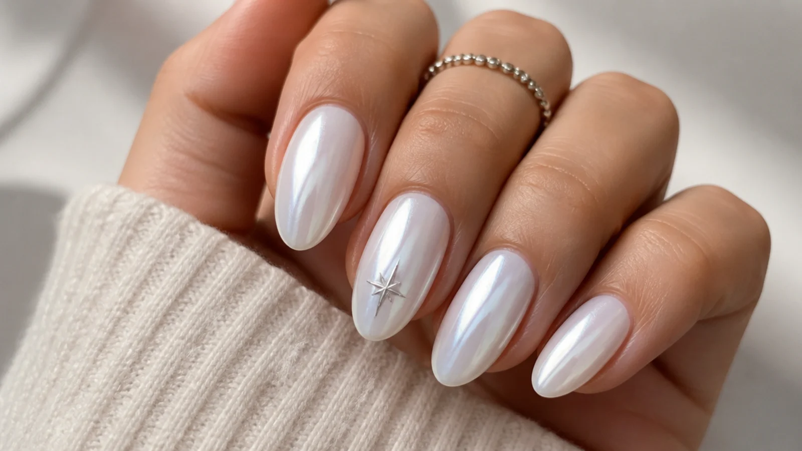 Milky white chrome nails with a tiny silver star accent on one nail