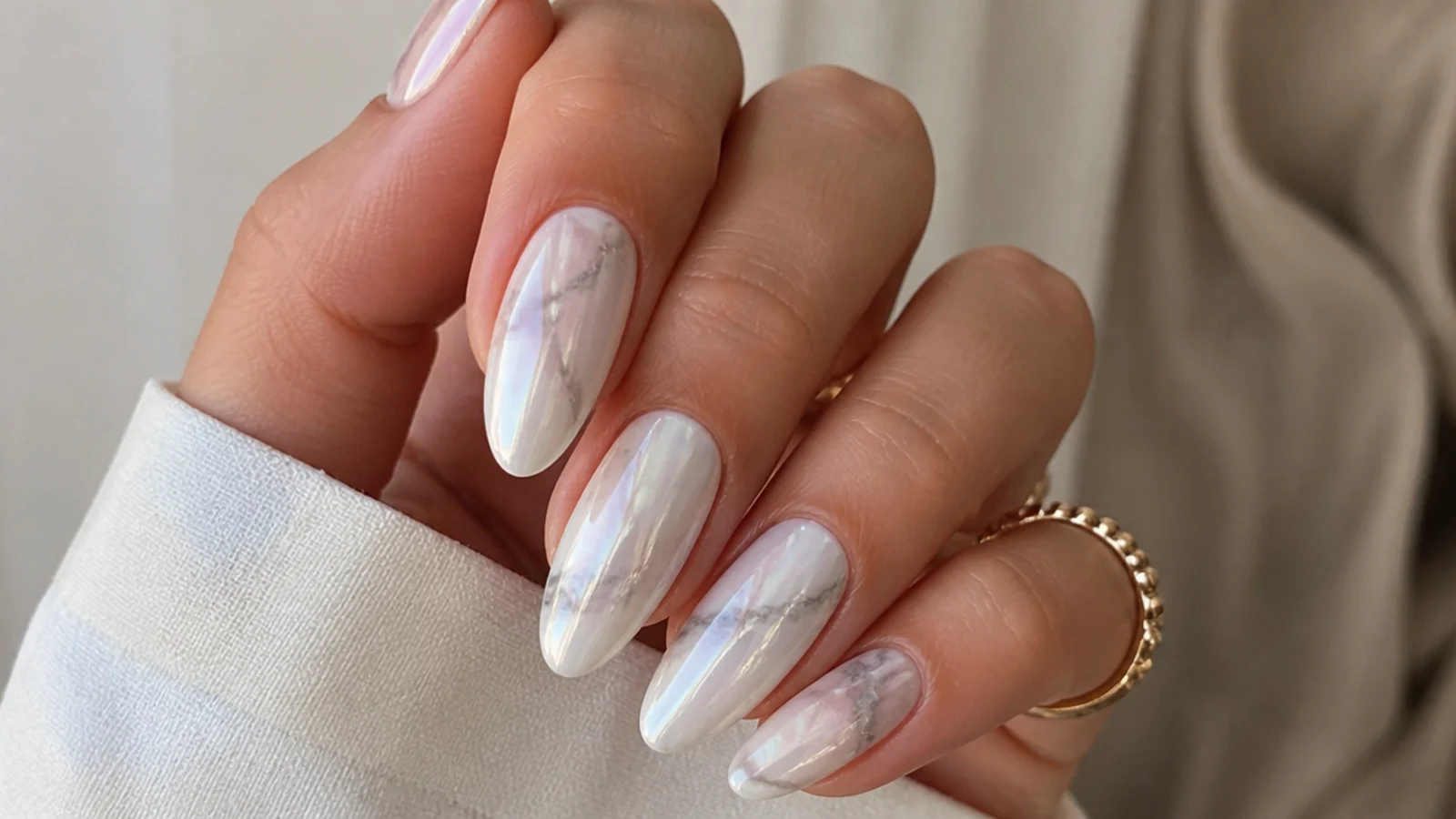 Milky white chrome nails with soft gray marble veining under pearl