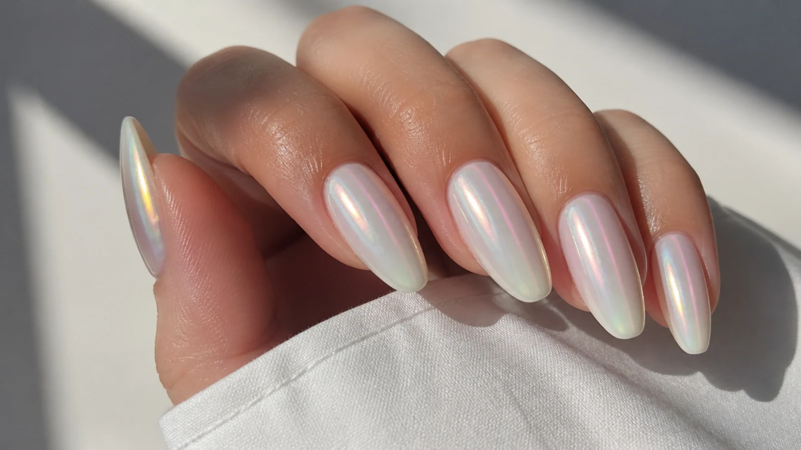 Off white chrome nails with an opal-like iridescent milky shimmer