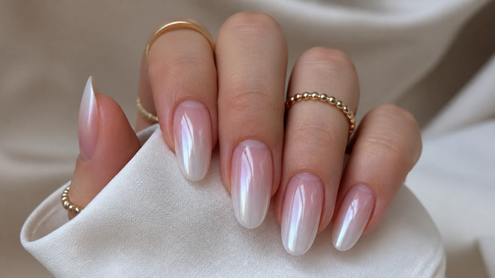 Off white chrome nails fading from milky white at the tip to sheer at the cuticle