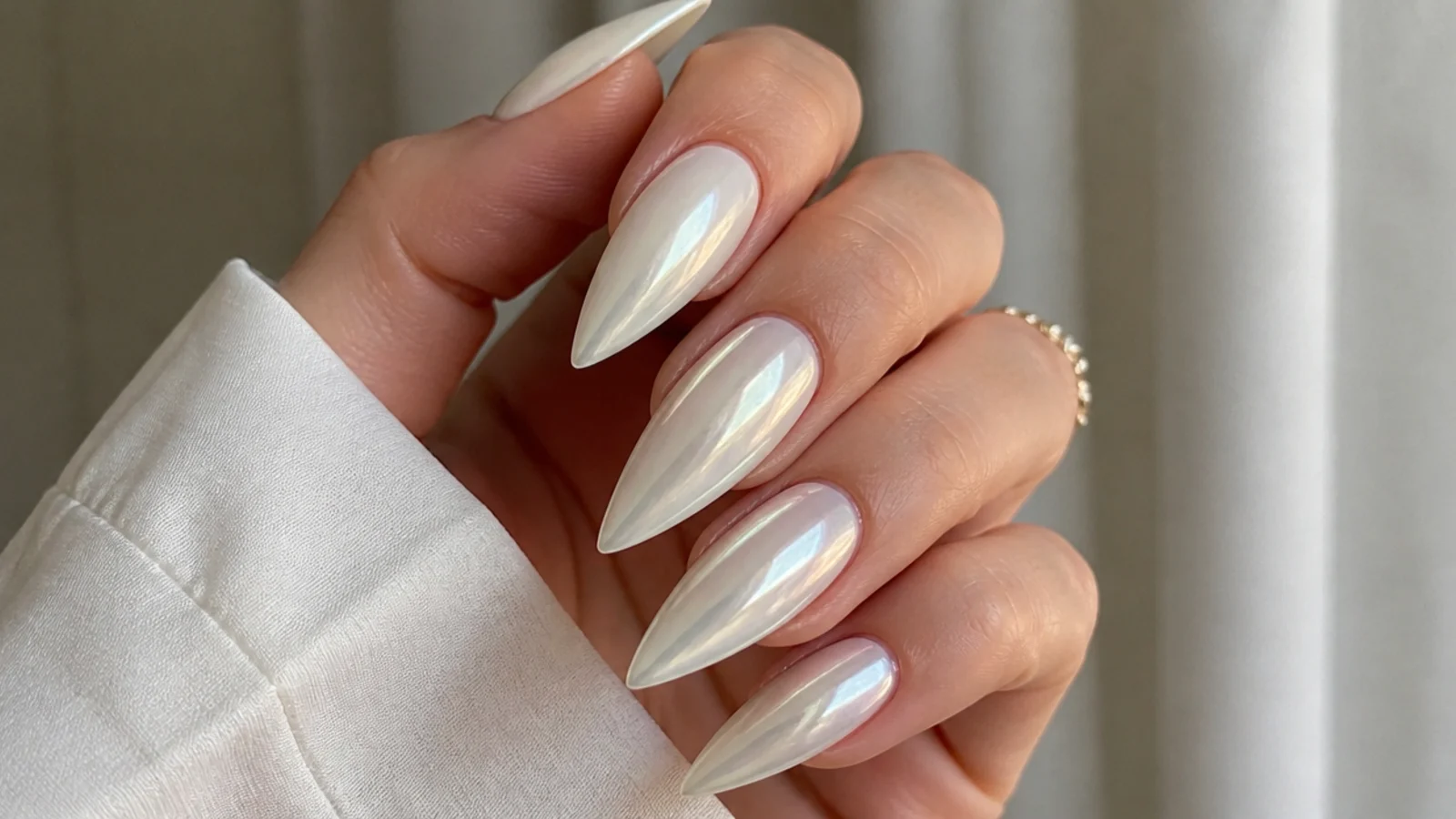 Long pointed stiletto pearl white chrome nails with a glassy sheen