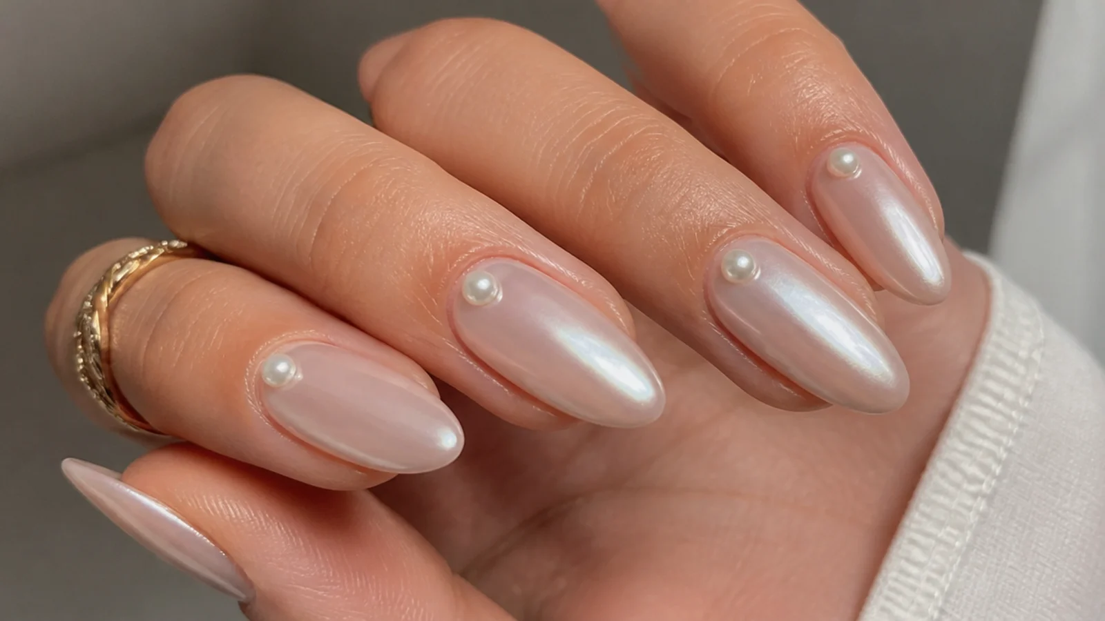 Milky pearl chrome nails with tiny 3D pearl beads at the cuticle