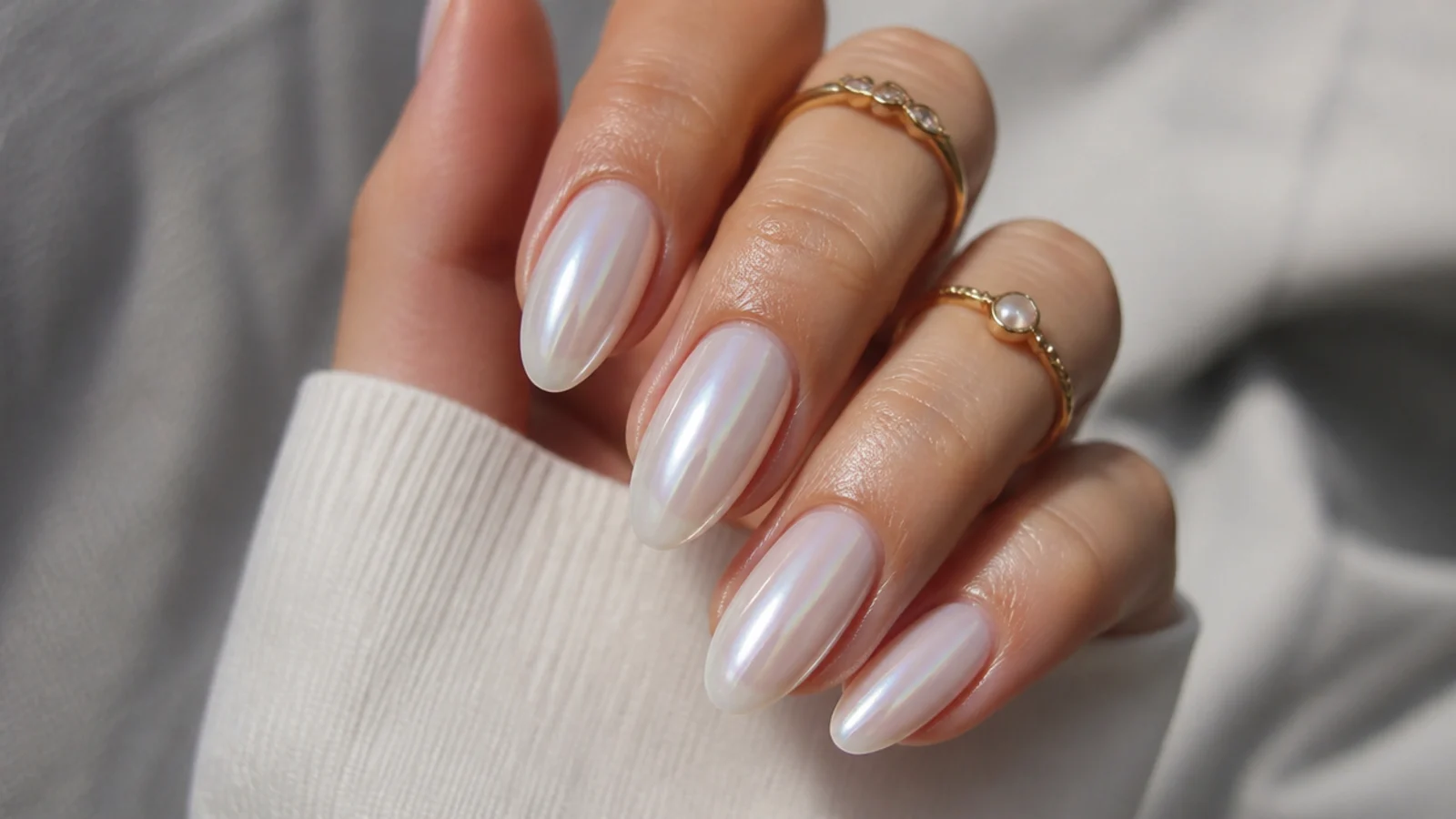 Glassy pearl white chrome nails with a soft glazed-donut glow on almond tips