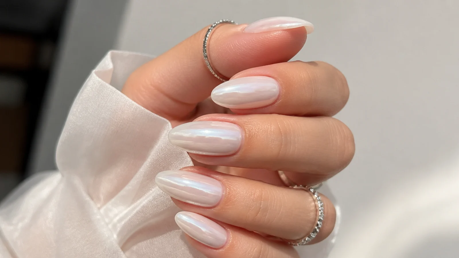 Opaque milky white almond nails with a soft pearl chrome sheen