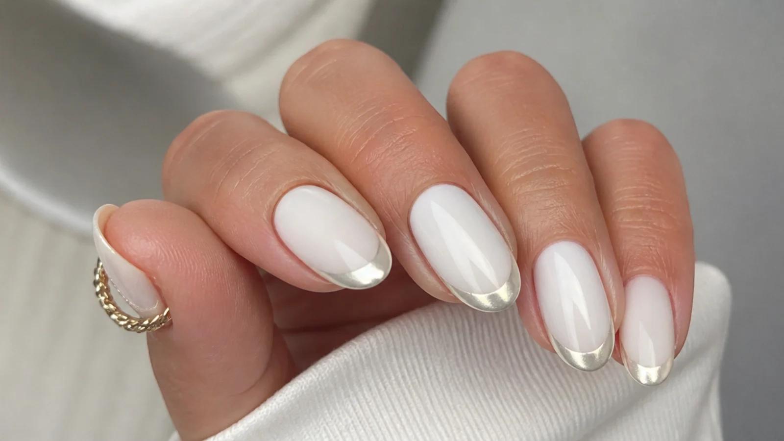 Short almond nails with a milky white base and pearl chrome french tip