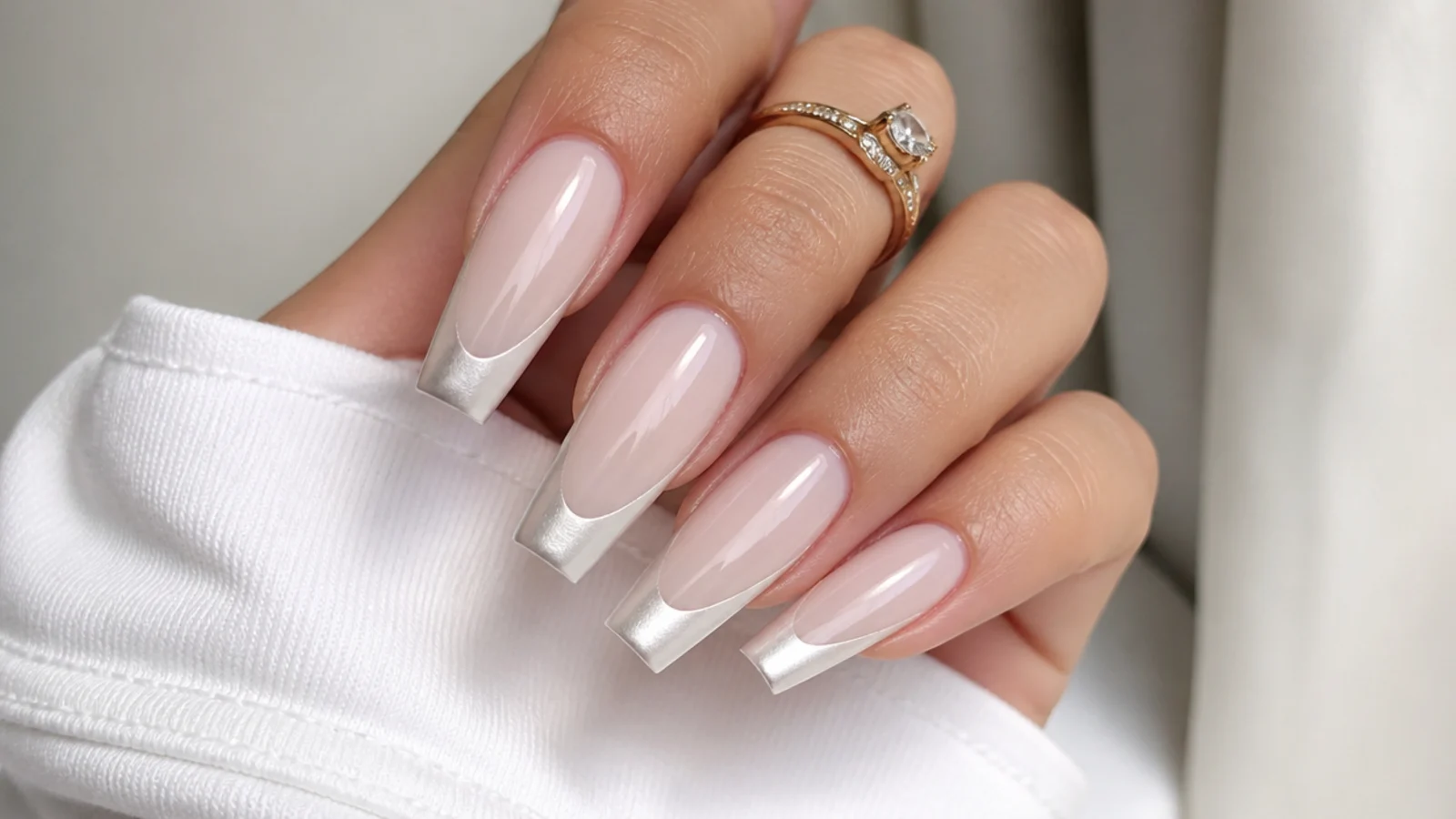 Long coffin nails with a milky base and soft pearl chrome french tip