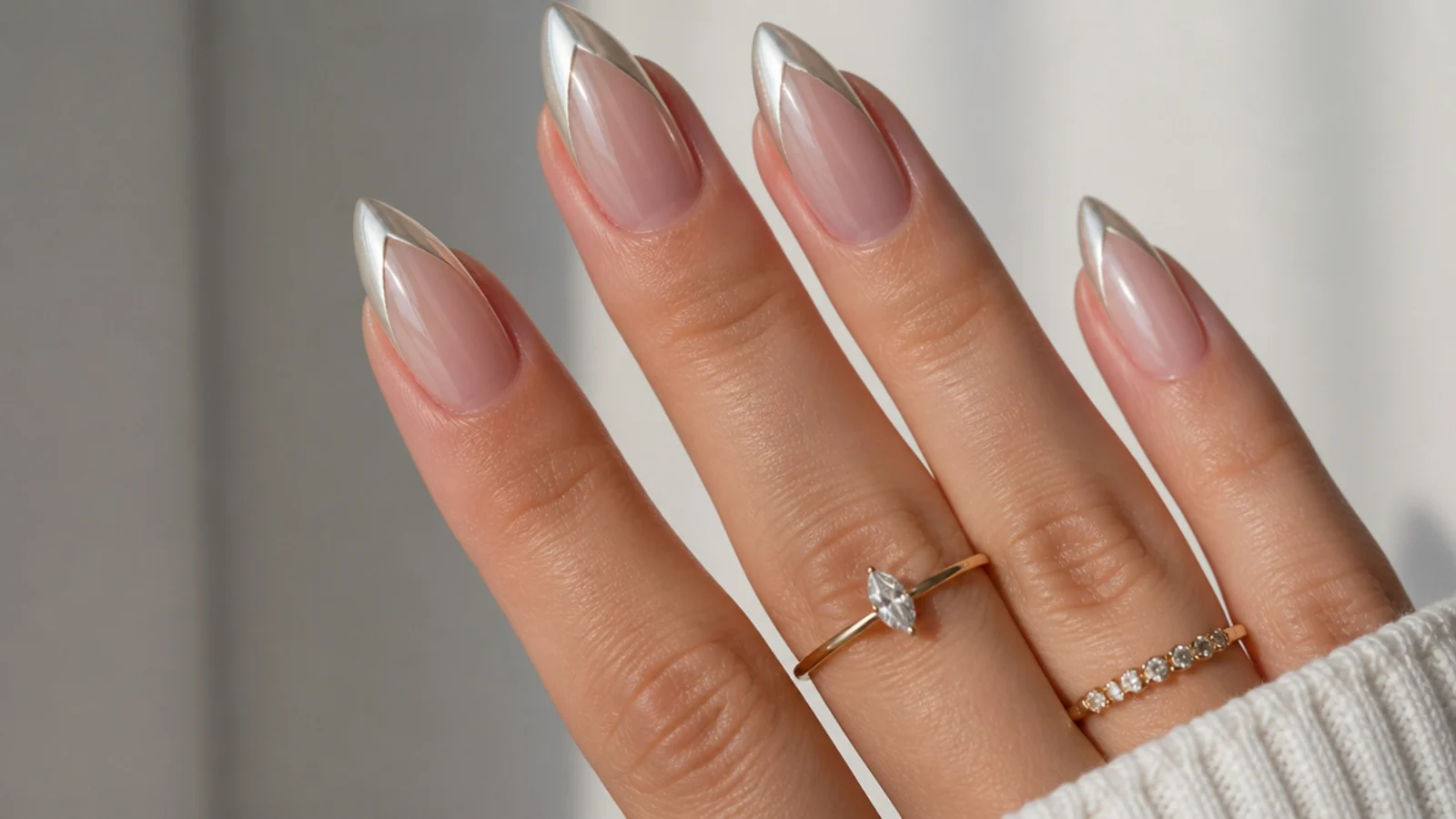 Almond nails with a pointed V-shaped pearl chrome french tip