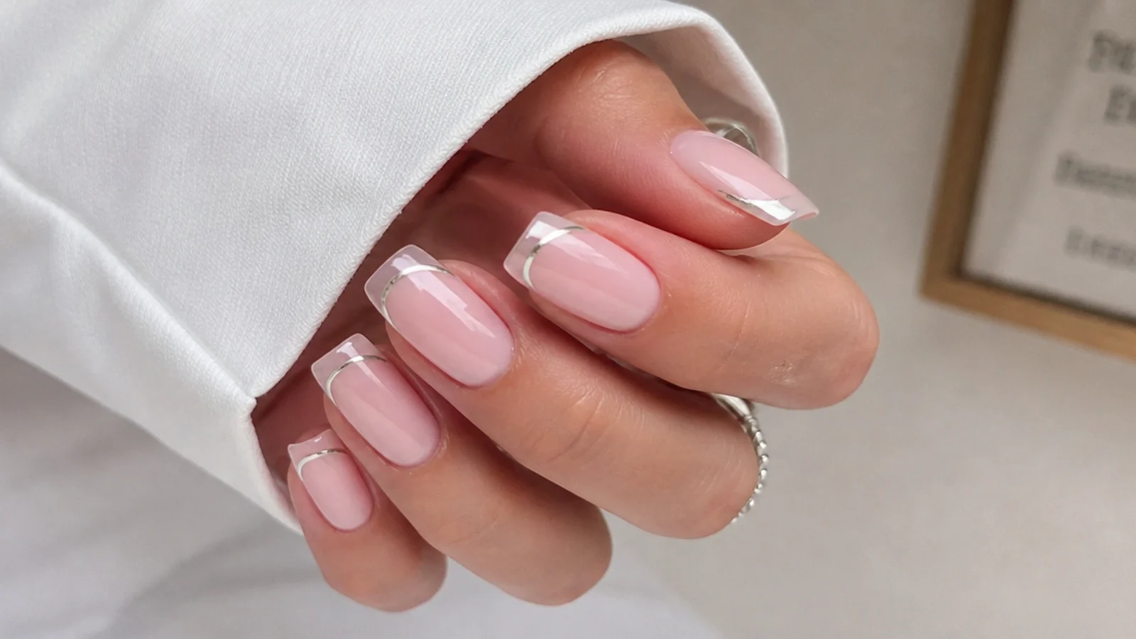 Square nails with a bare tip outlined by a thin pearl chrome french line
