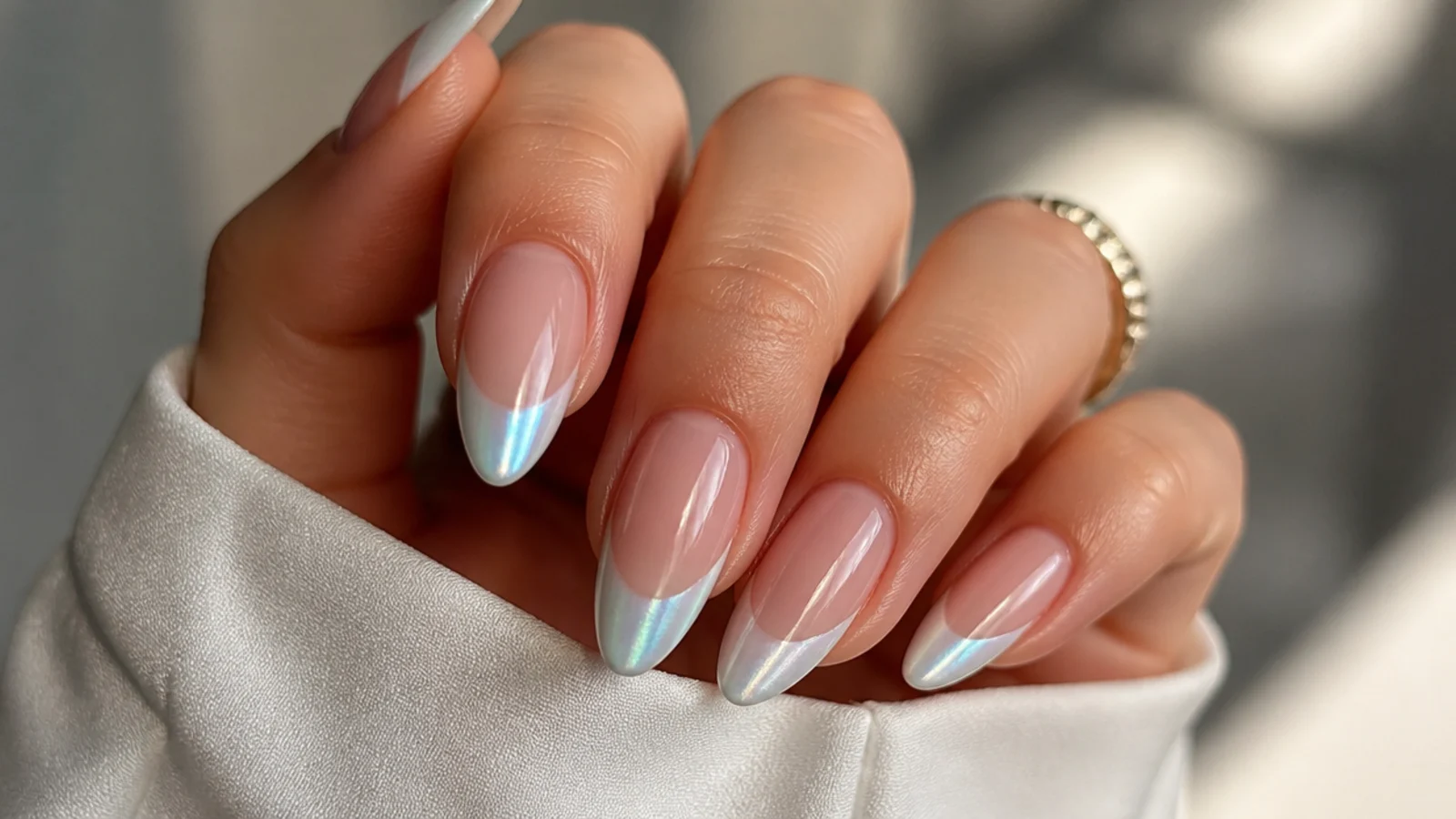 Almond nails with a cool, icy blue-white pearl chrome french tip
