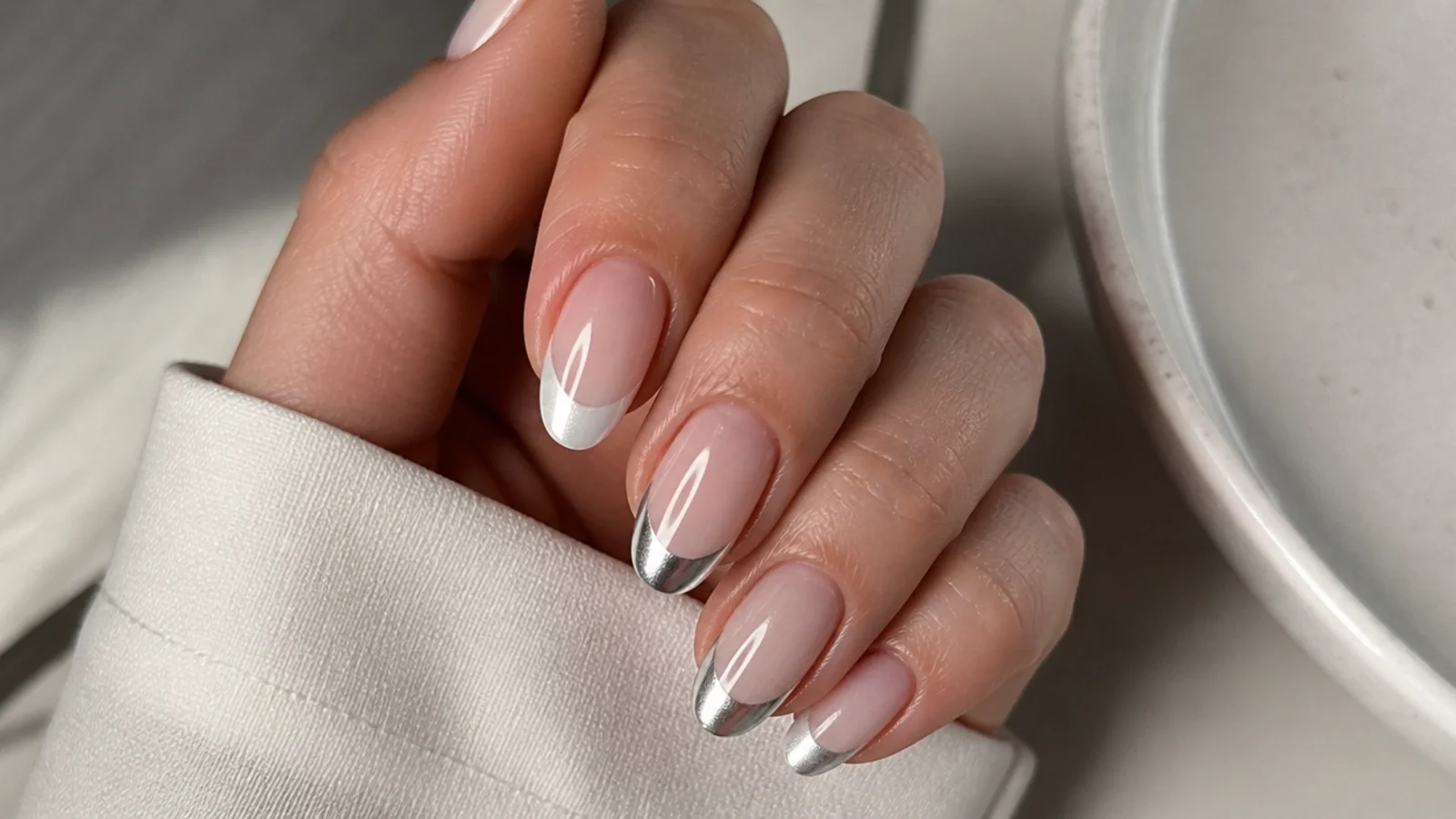 A soft pearl white chrome tip beside a bright mirror silver chrome tip