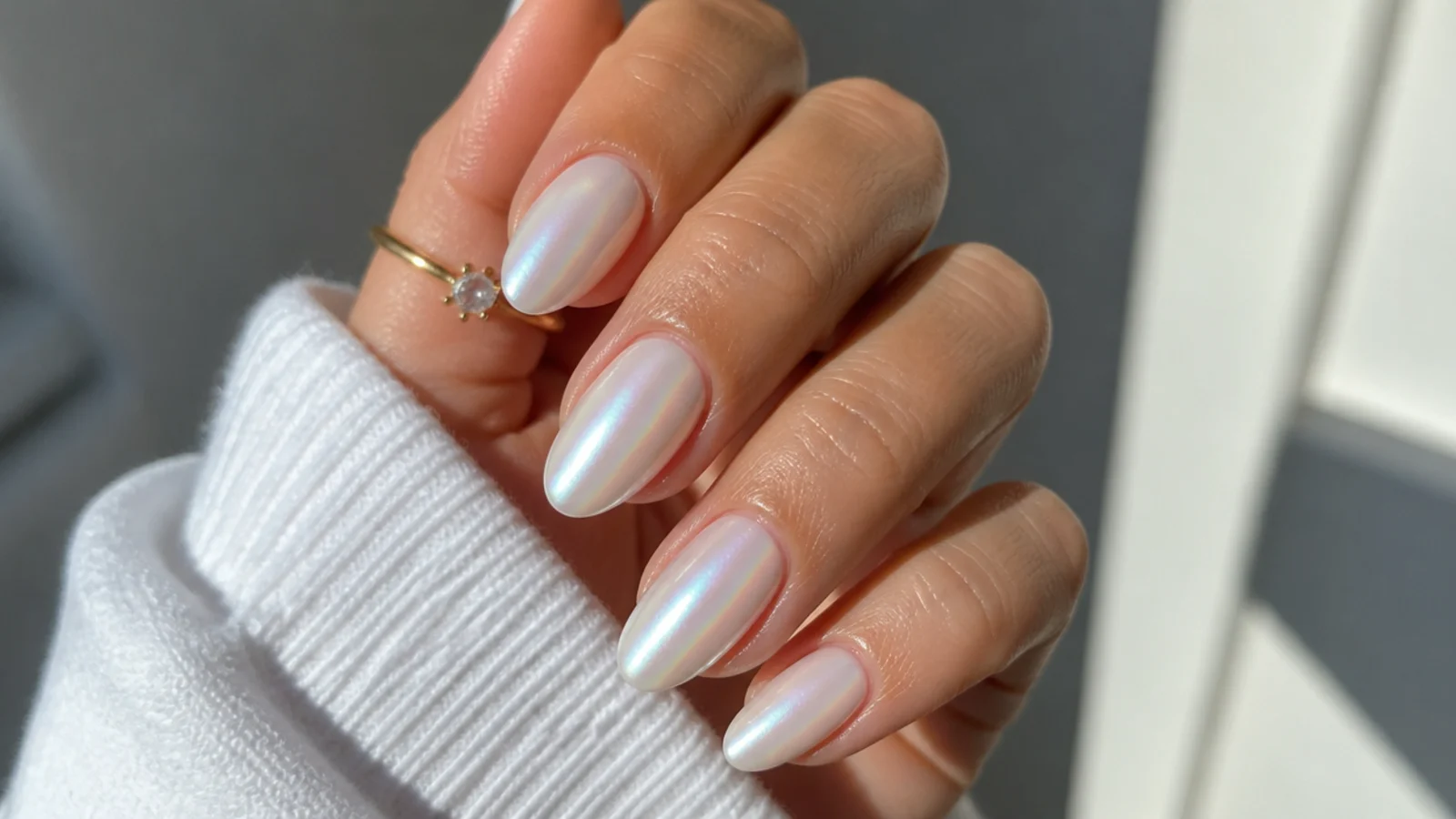 Milky white pearl chrome almond nails with a soft opal sheen