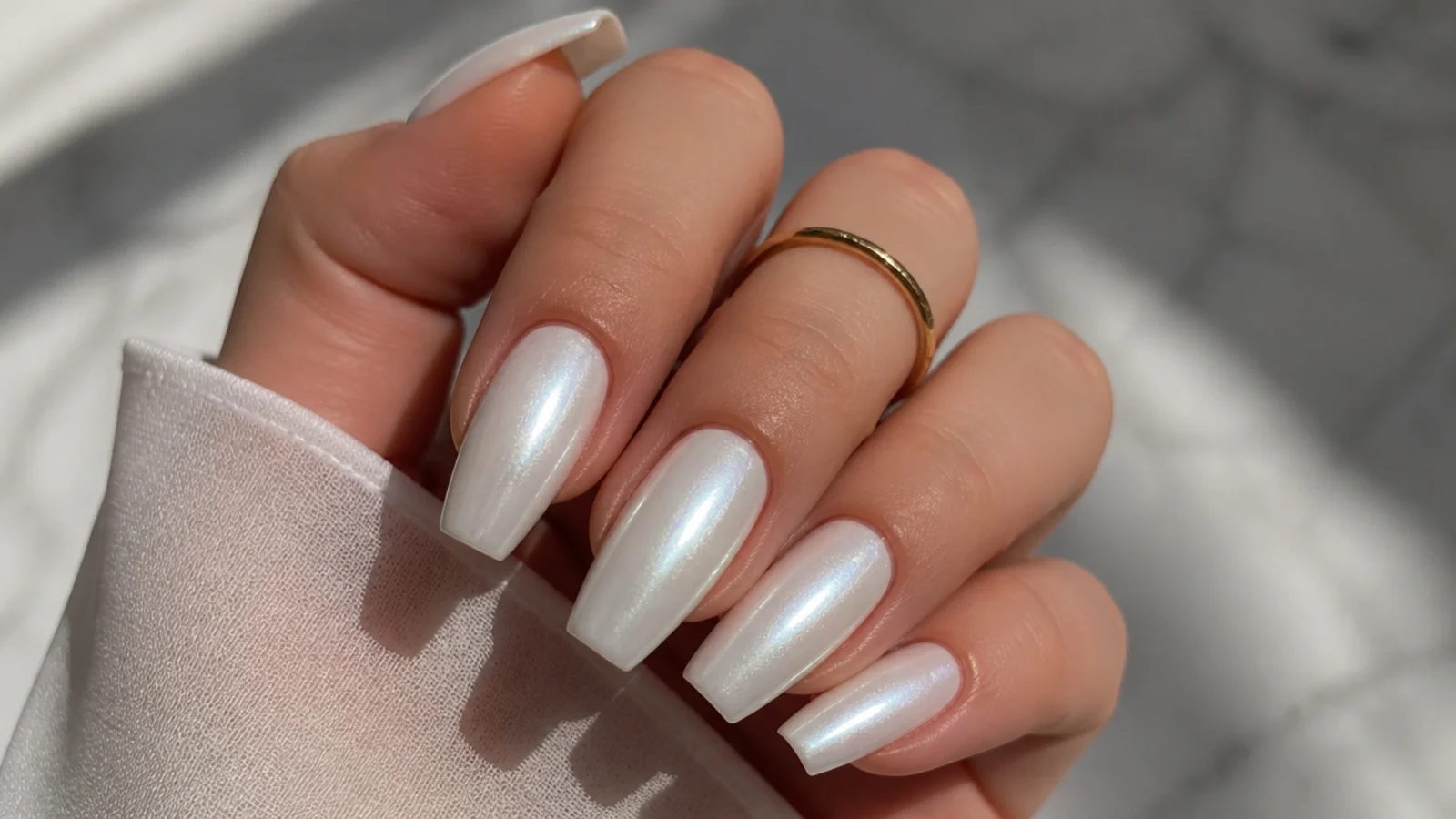 Soft bridal white pearl chrome nails on a medium coffin shape
