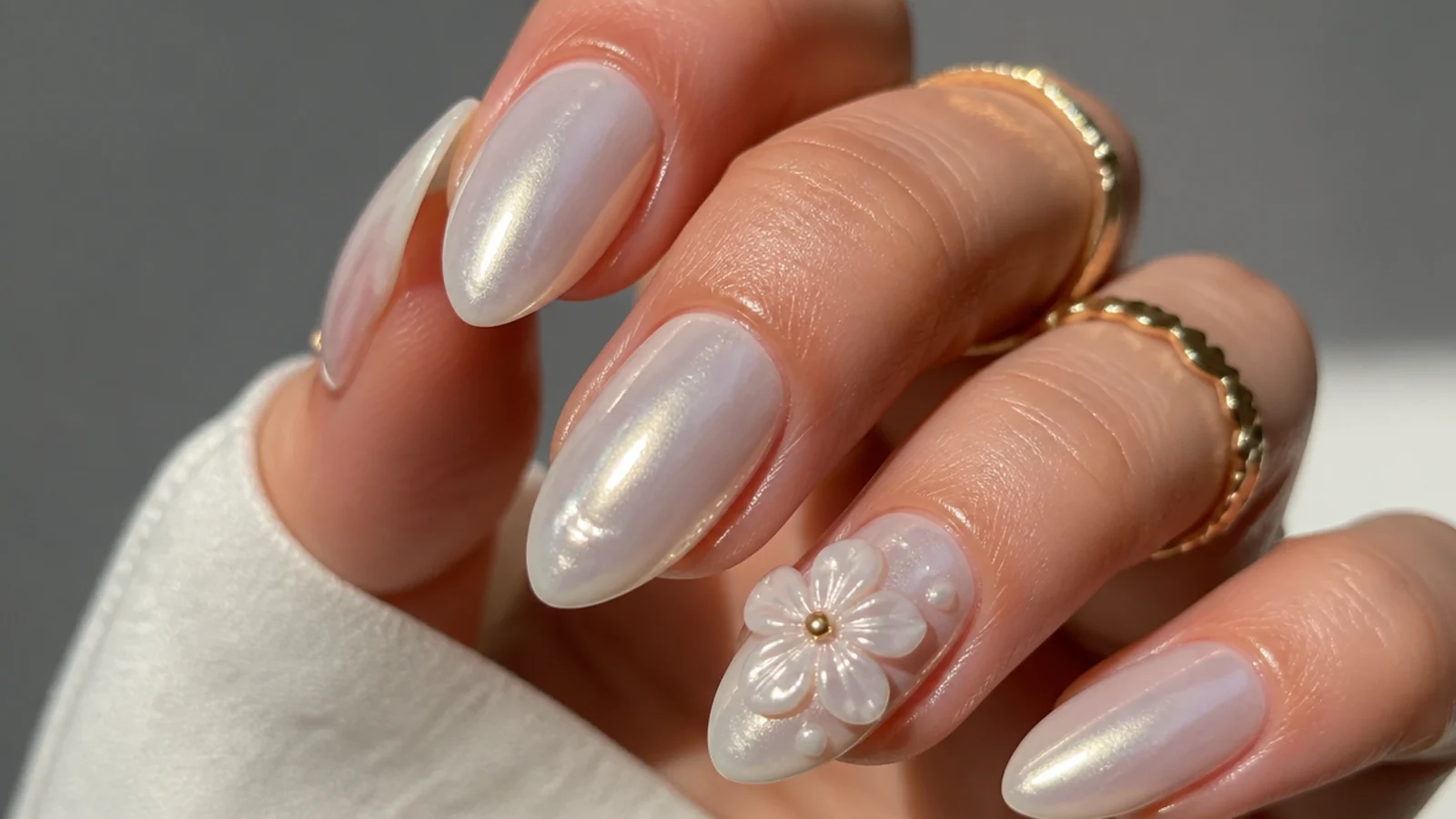 Milky white chrome nails with a raised white 3D flower accent
