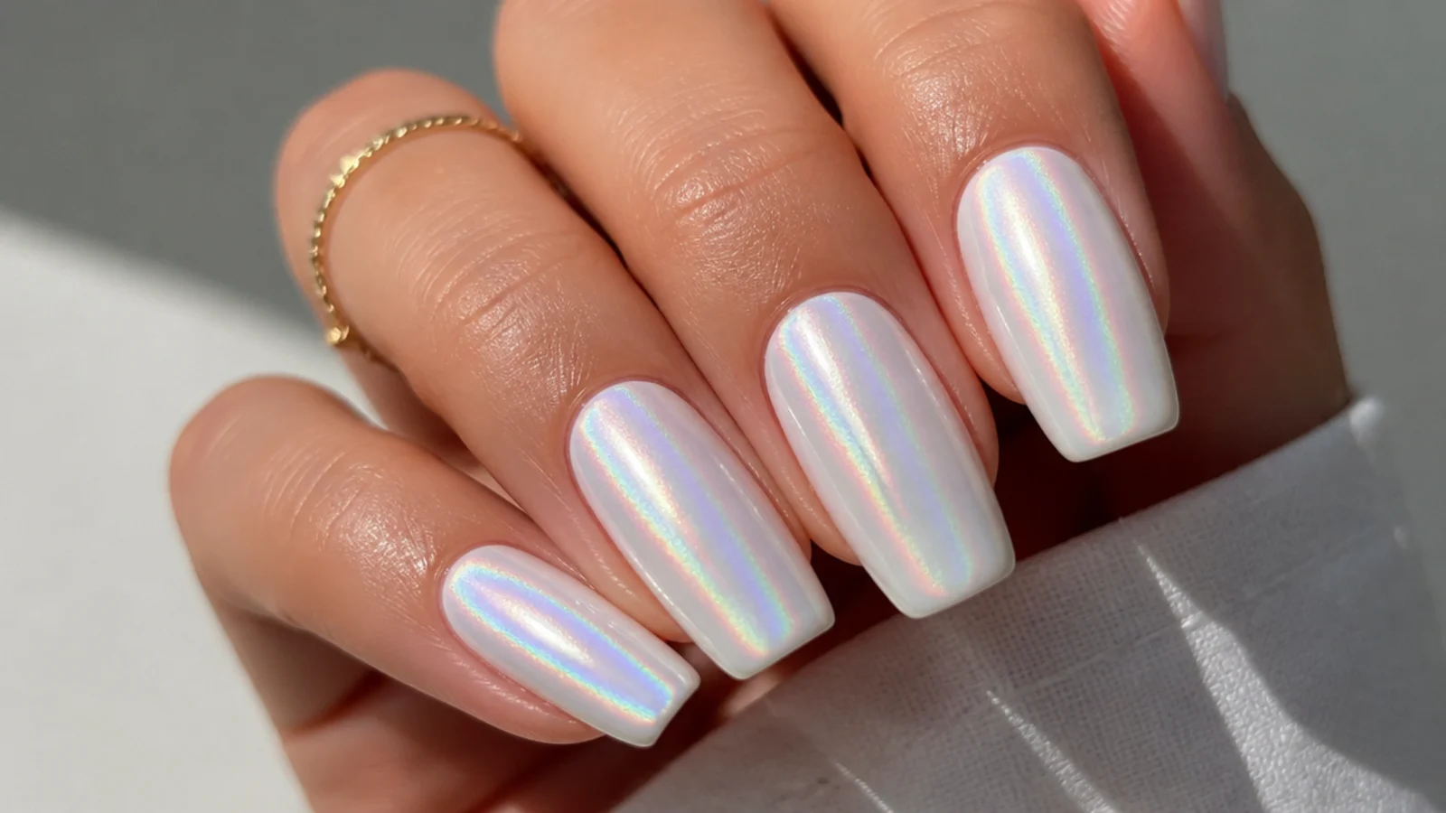 White nails with a rainbow holographic chrome shift in the light