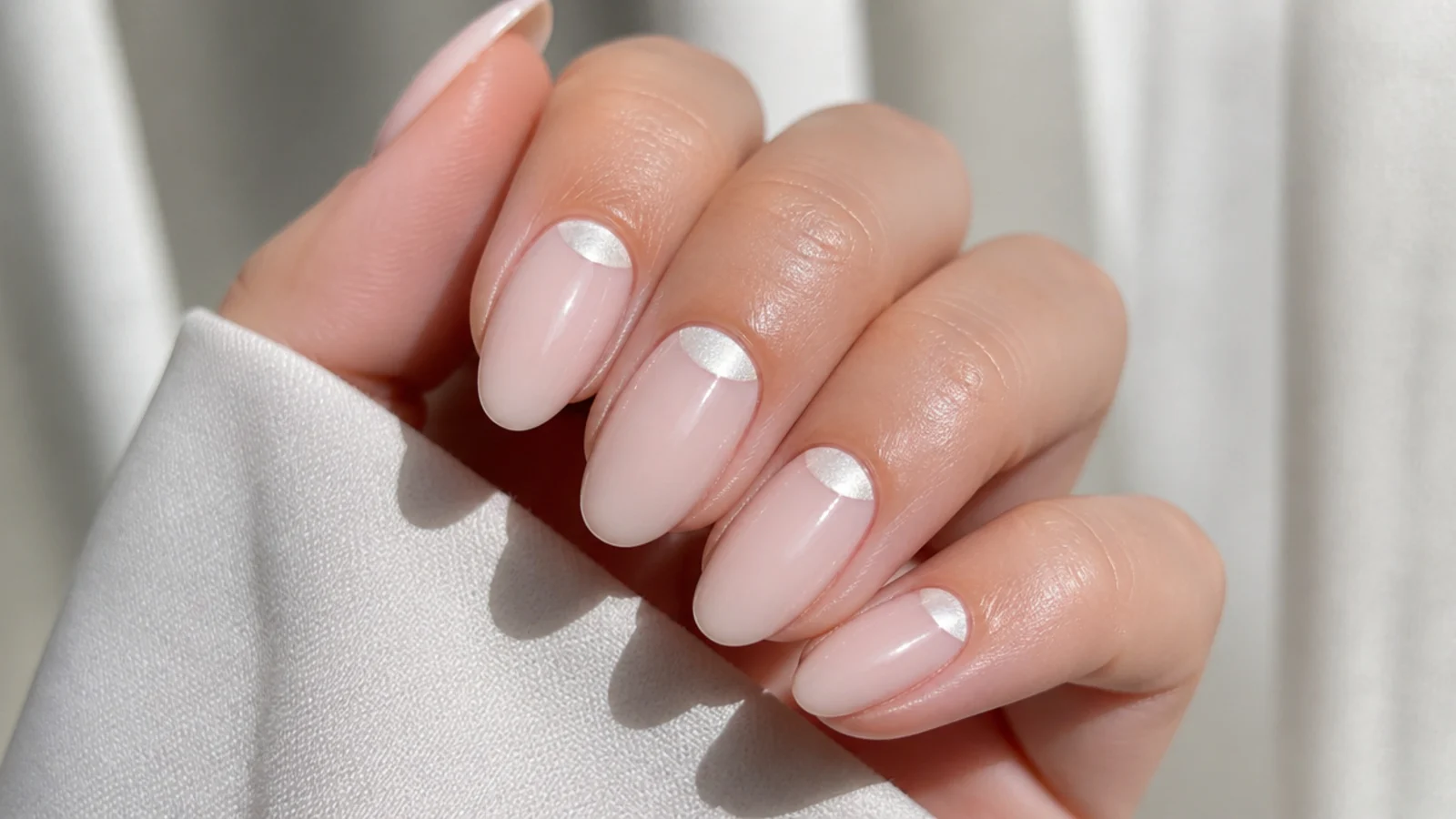 Milky nails with a white chrome half-moon at the cuticle base