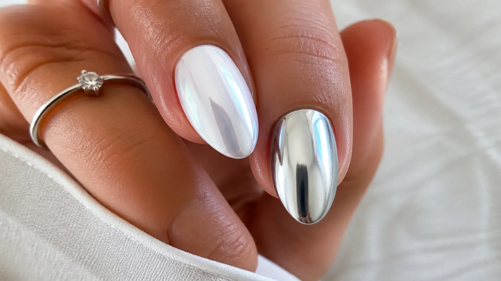Soft pearl white chrome nail beside a bright mirror silver chrome nail