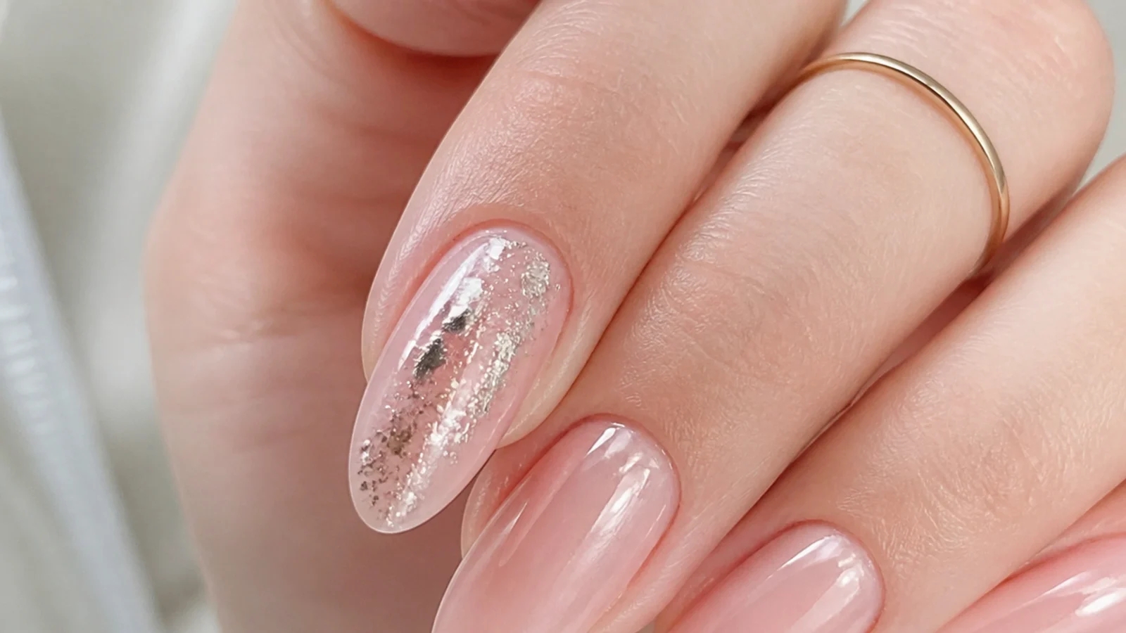 Grainy clumped chrome powder on a sticky gel surface on a single nail