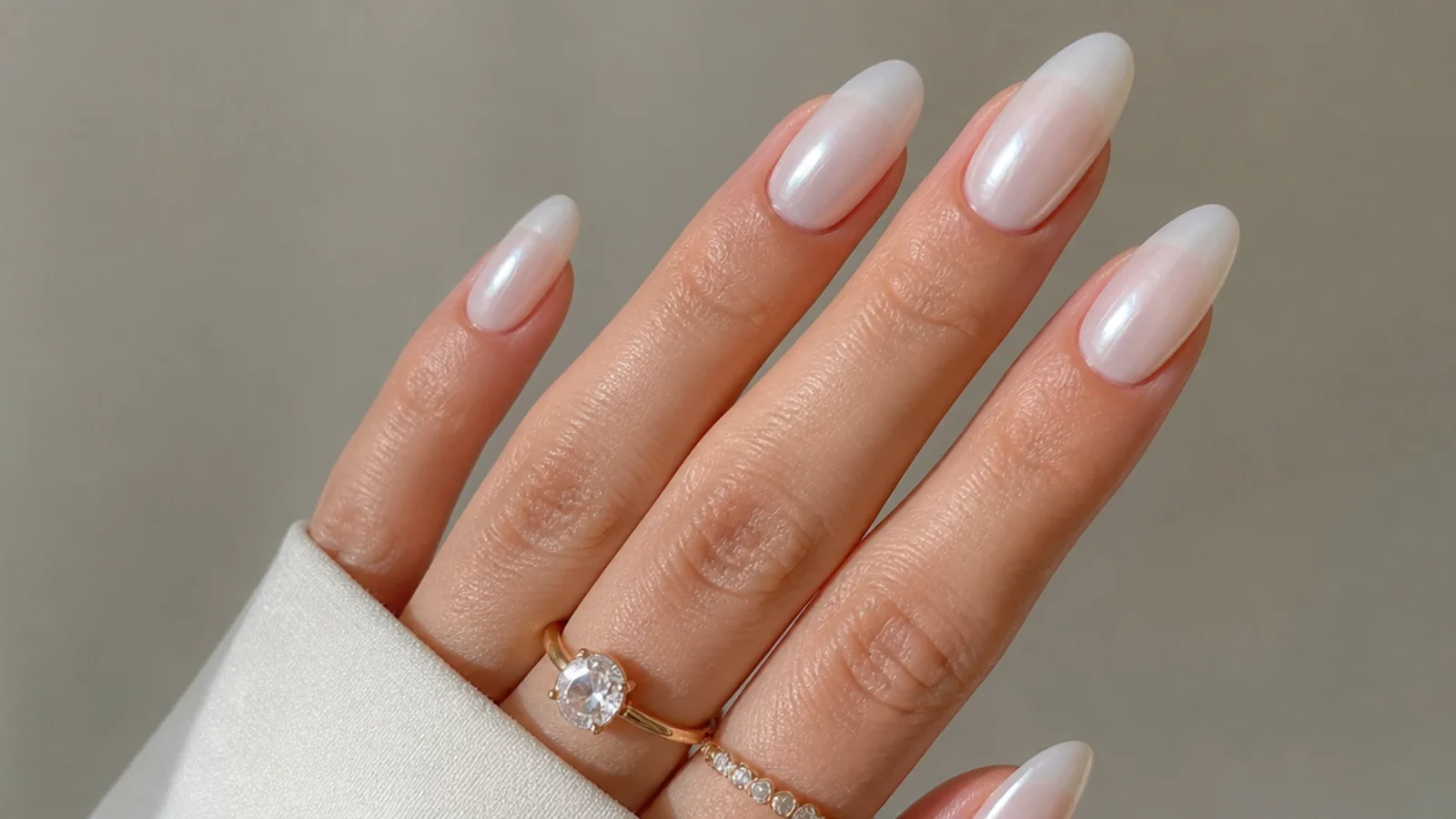 Glassy milky white chrome nails with a glazed-donut pearl glow on almond tips
