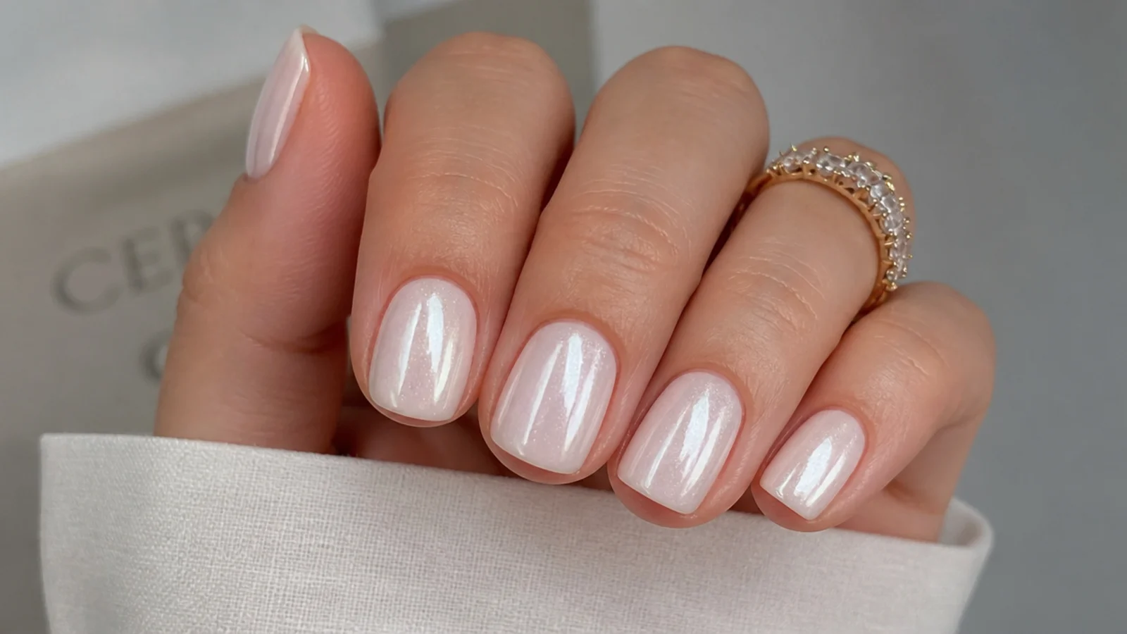 Short squoval white chrome nails with a soft sheer pearl glaze