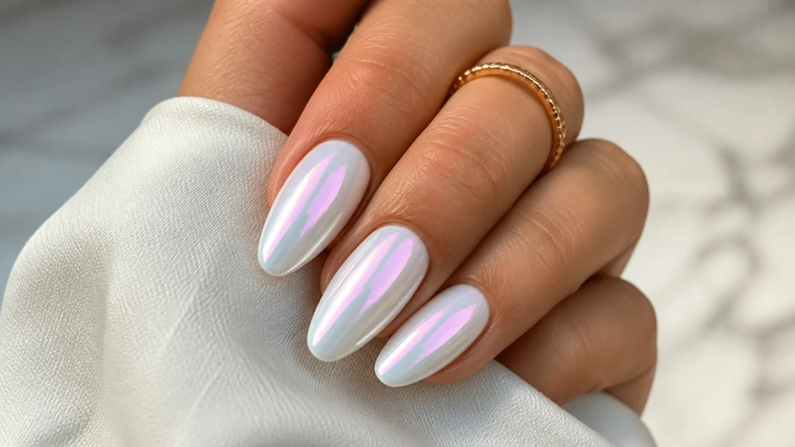 White chrome nails with an aurora pink and blue pearl color shift