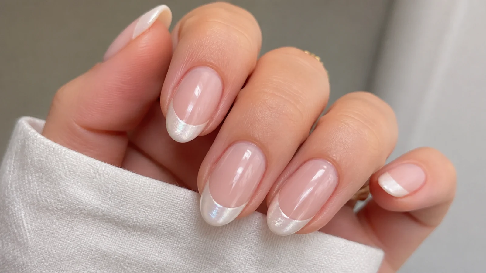 White chrome French tip nails with a pearl glazed tip over a nude base