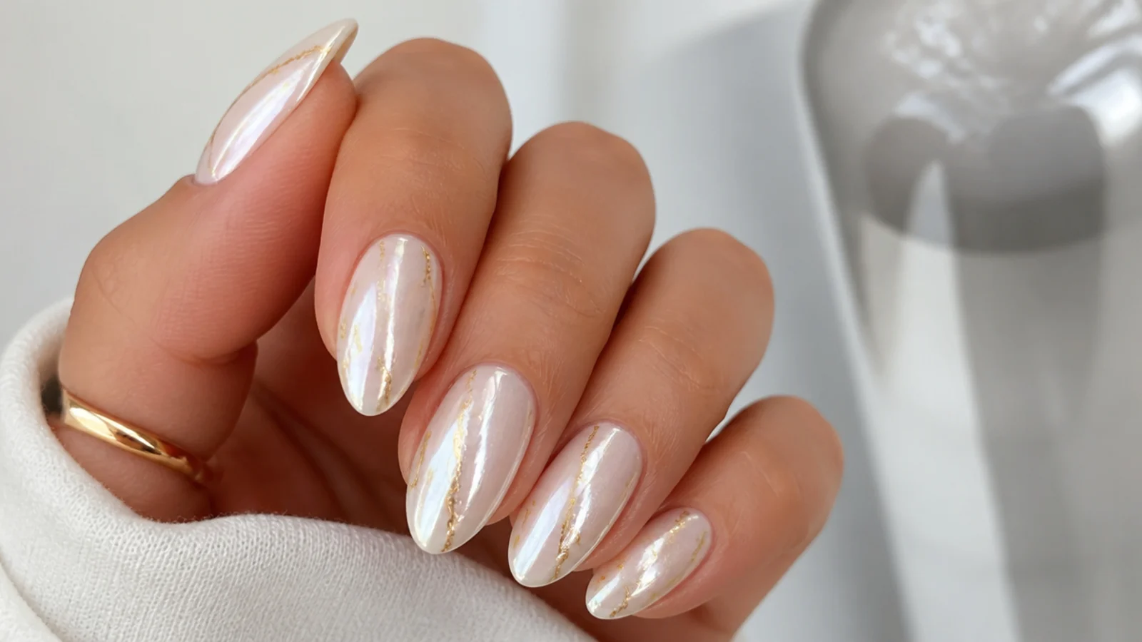 Pearl white chrome nails with a fine gold foil accent line