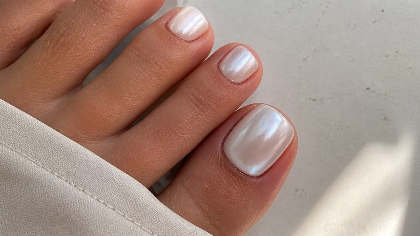 Pearl white chrome pedicure toes with a soft glazed glow