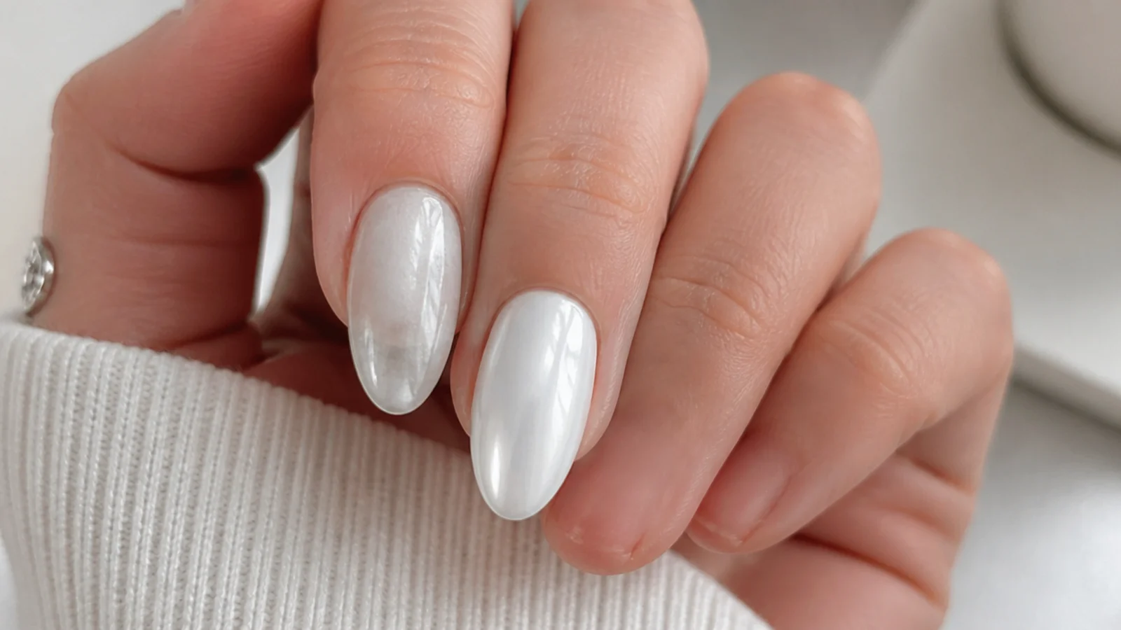 A dull patchy chrome nail beside a glassy well-buffed white chrome nail