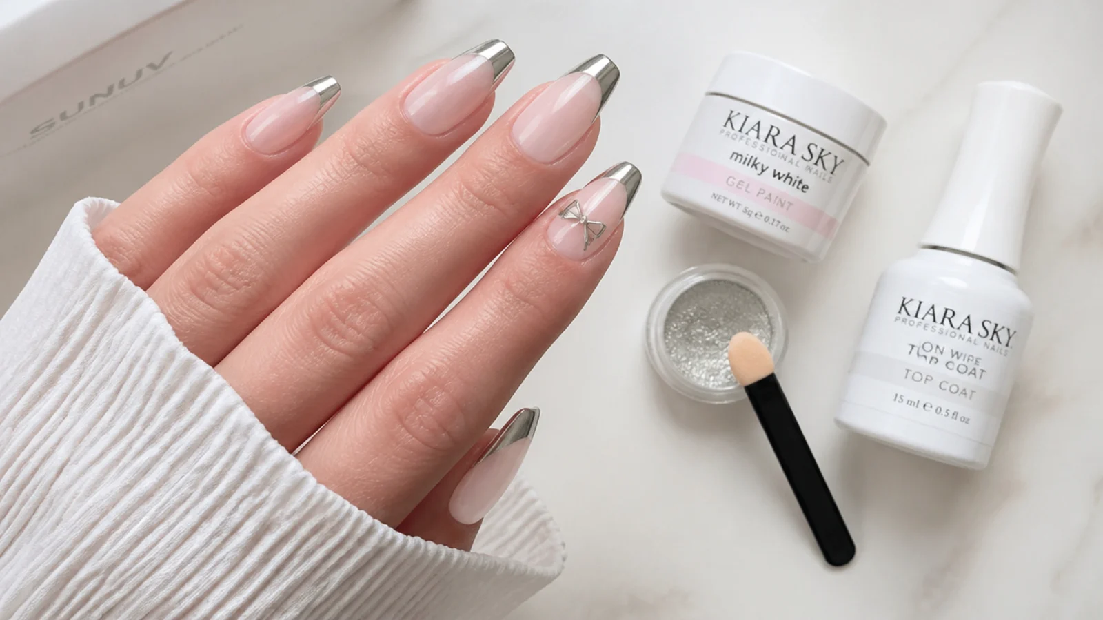 Flat lay of milky gel, chrome powder, applicator, LED lamp and no-wipe top coat
