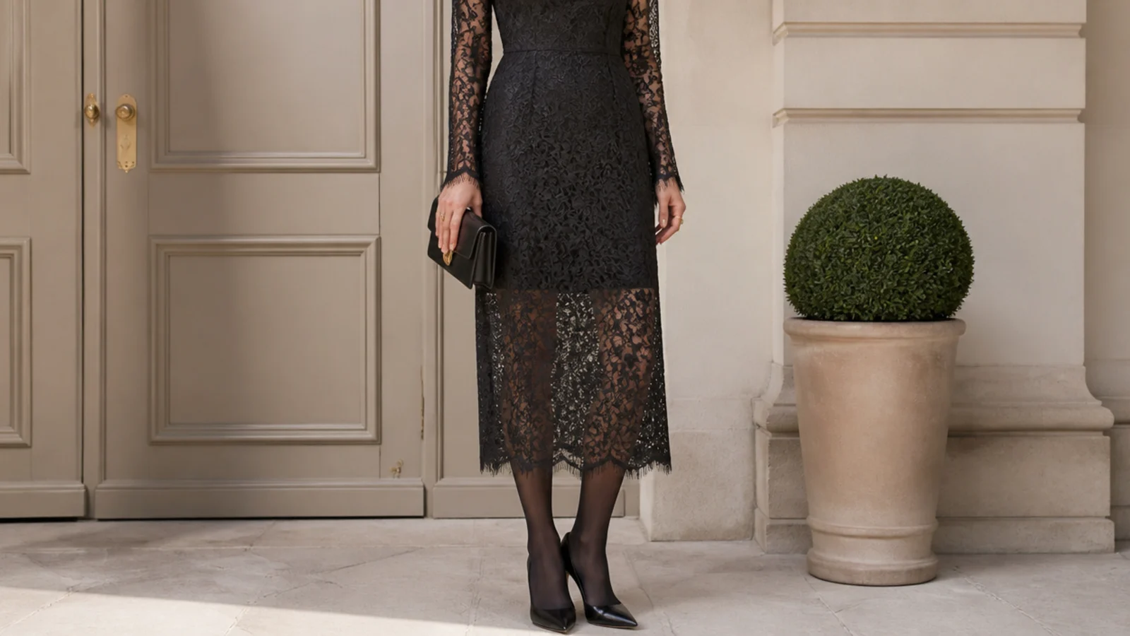 Faceless full-length shot of a black lace midi dress over a slip with sheer black tights and heels