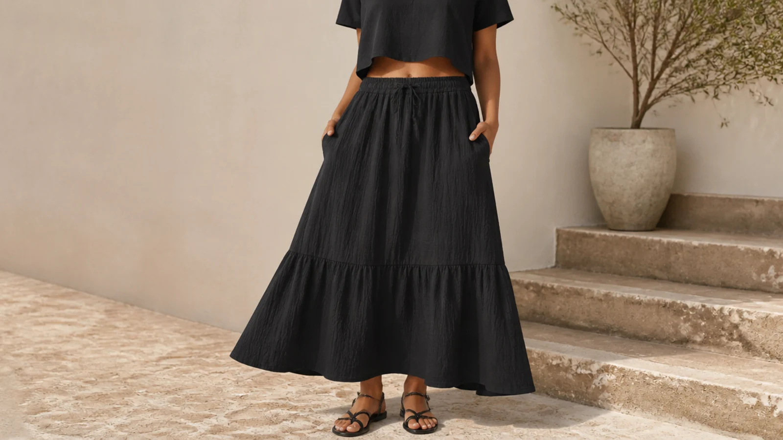 Faceless shot of a black crinkle cotton midi skirt with a black cropped cotton tee