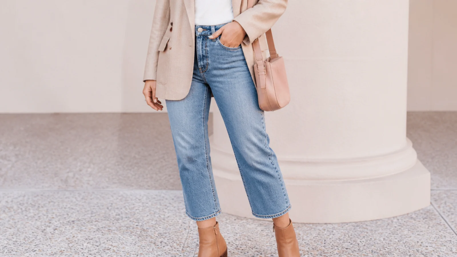 Faceless outfit with cropped straight-leg jeans ending above leather ankle boots showing a sliver of ankle