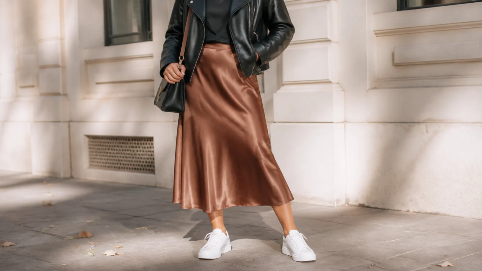 Faceless fall outfit with white sneakers, a bronze satin midi skirt and a black leather jacket