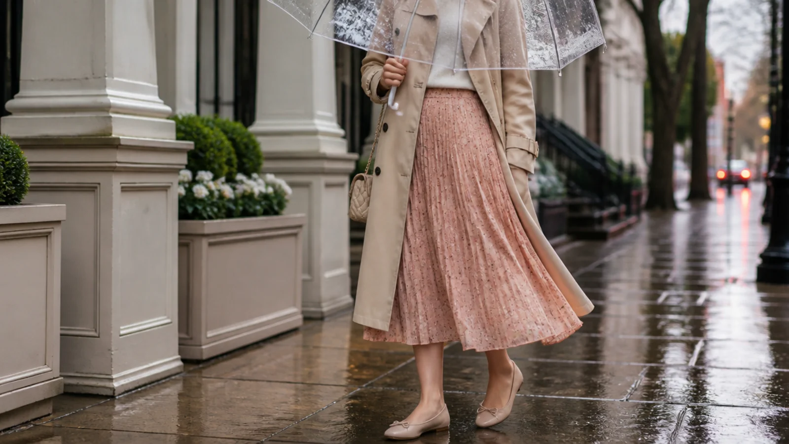 Faceless outfit under a clear bubble dome umbrella over a trench coat and midi skirt in the rain