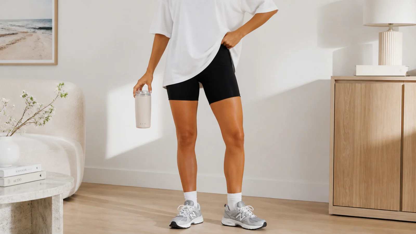 Faceless outfit with black bike shorts, an oversized white tee and low running sneakers
